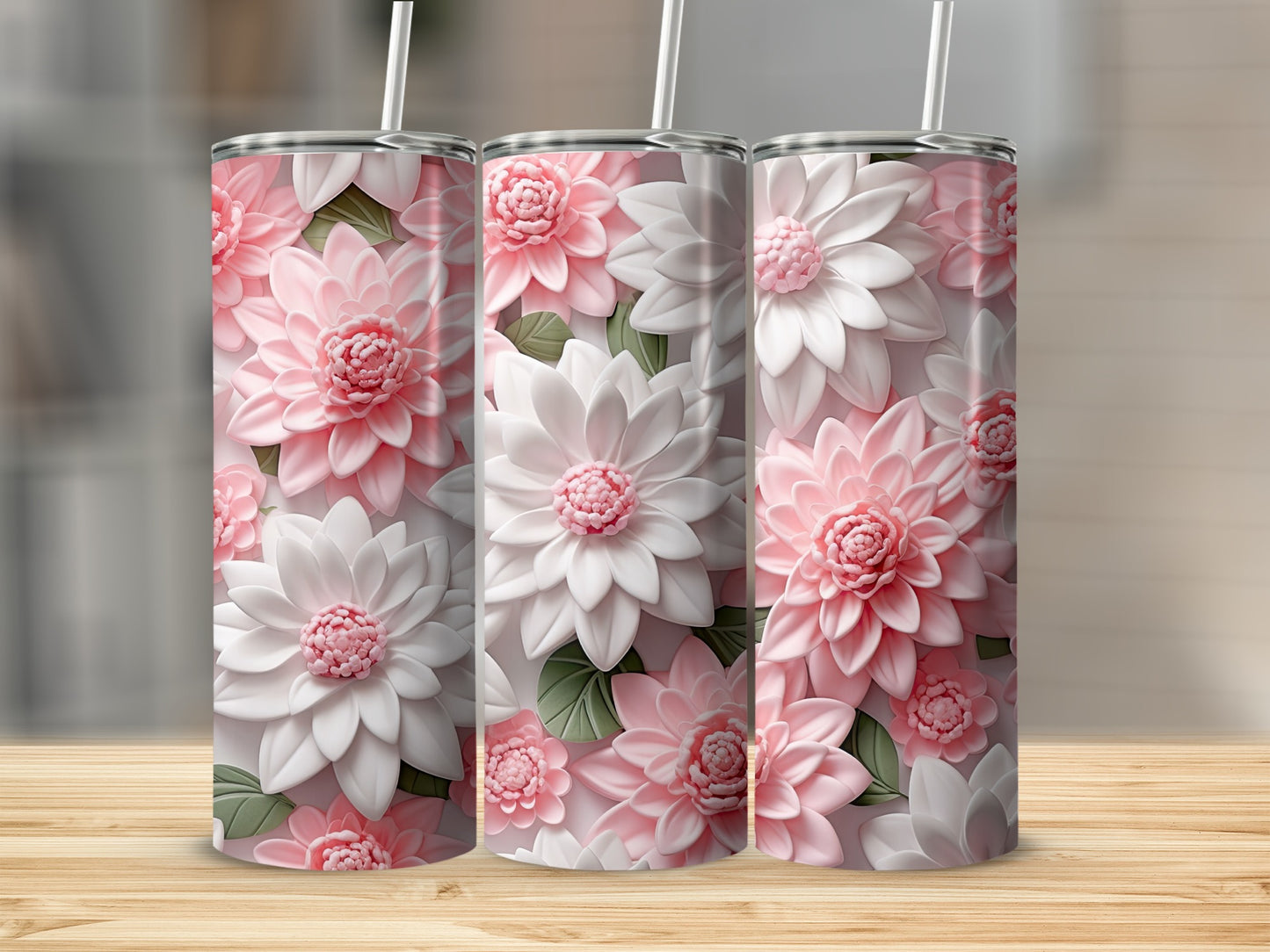 Three pink and white floral patterned tumblers with straws.