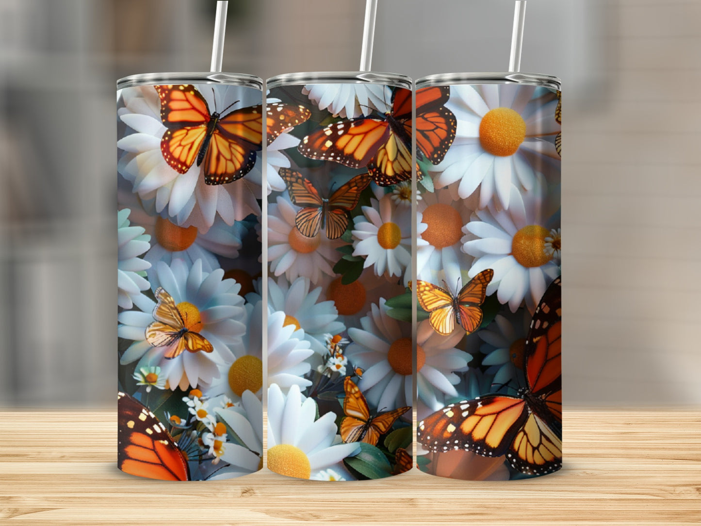 Butterflies and daisies decorate three tumblers on a wooden surface.