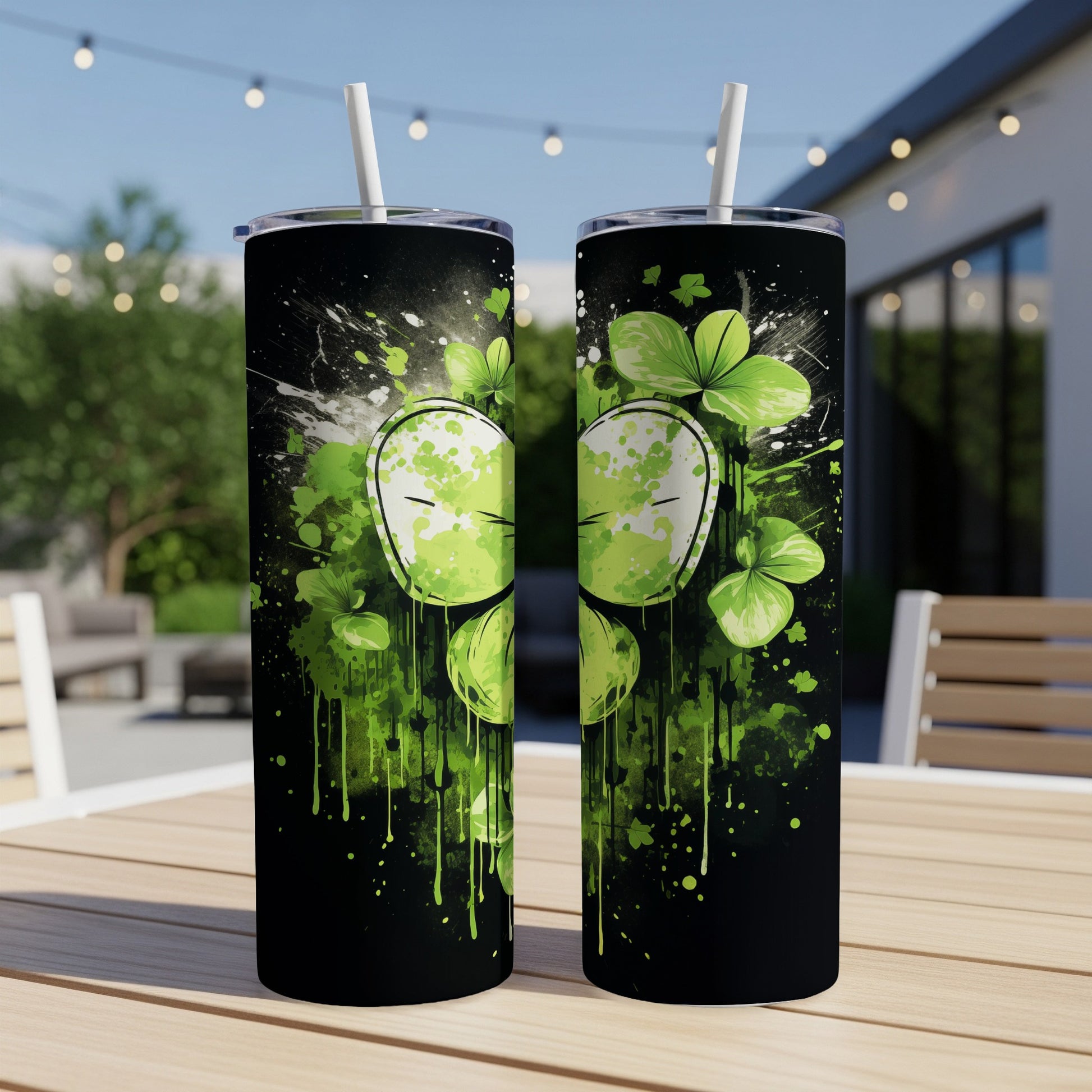 Green shamrocks and splatters on a black tumbler with a stylized white face.
