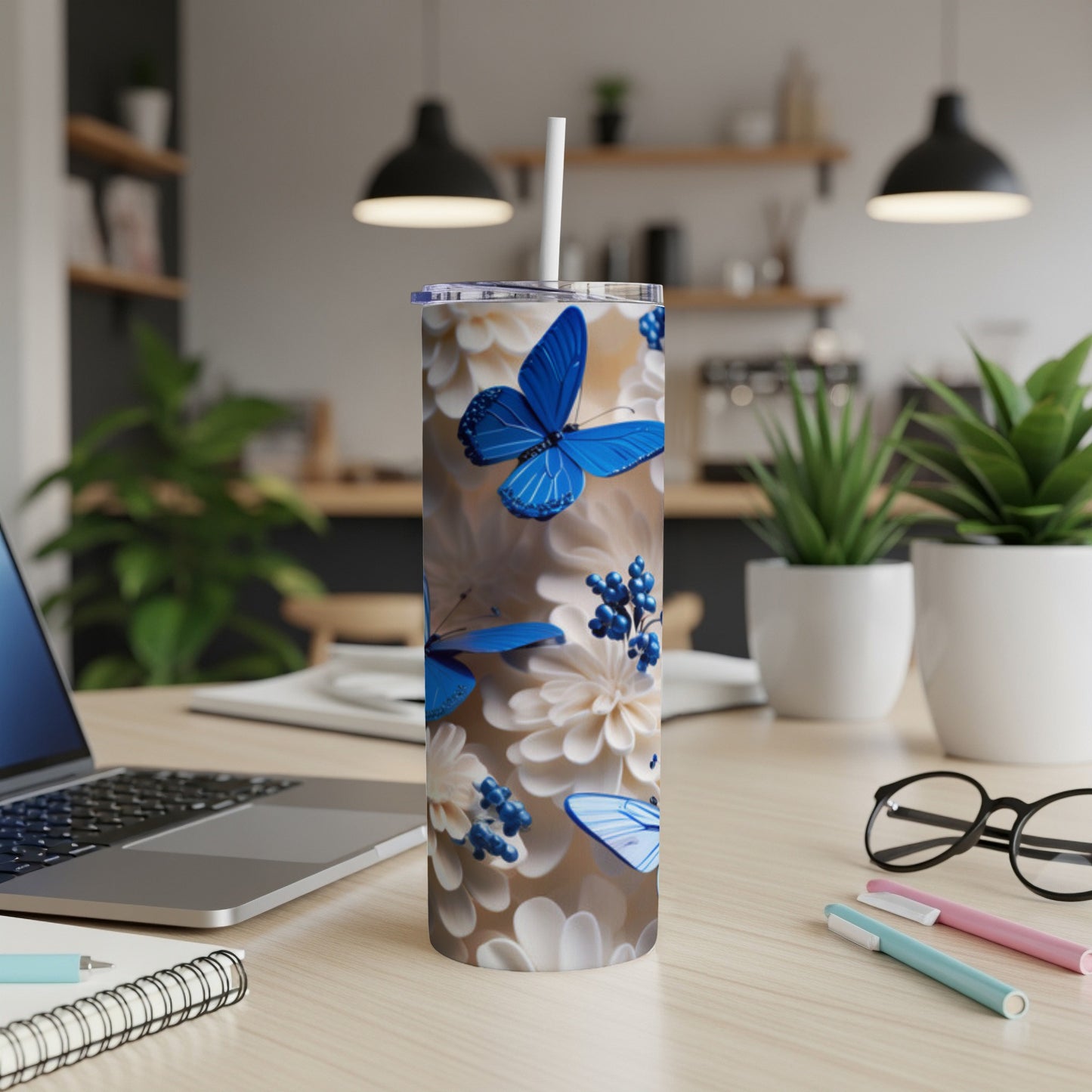 Blue butterflies and white flowers adorn this blue stainless steel tumbler.