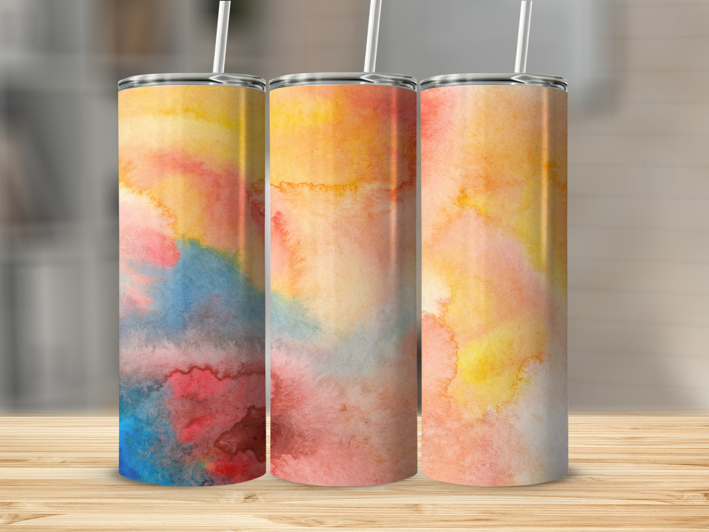 Three tumblers with watercolor abstract art of blue, pink, and yellow.