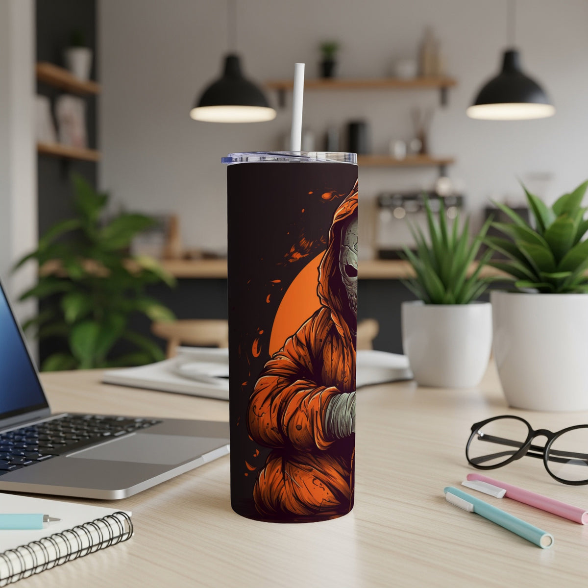Tumbler with Grim Reaper graphic, white straw, on a desk.