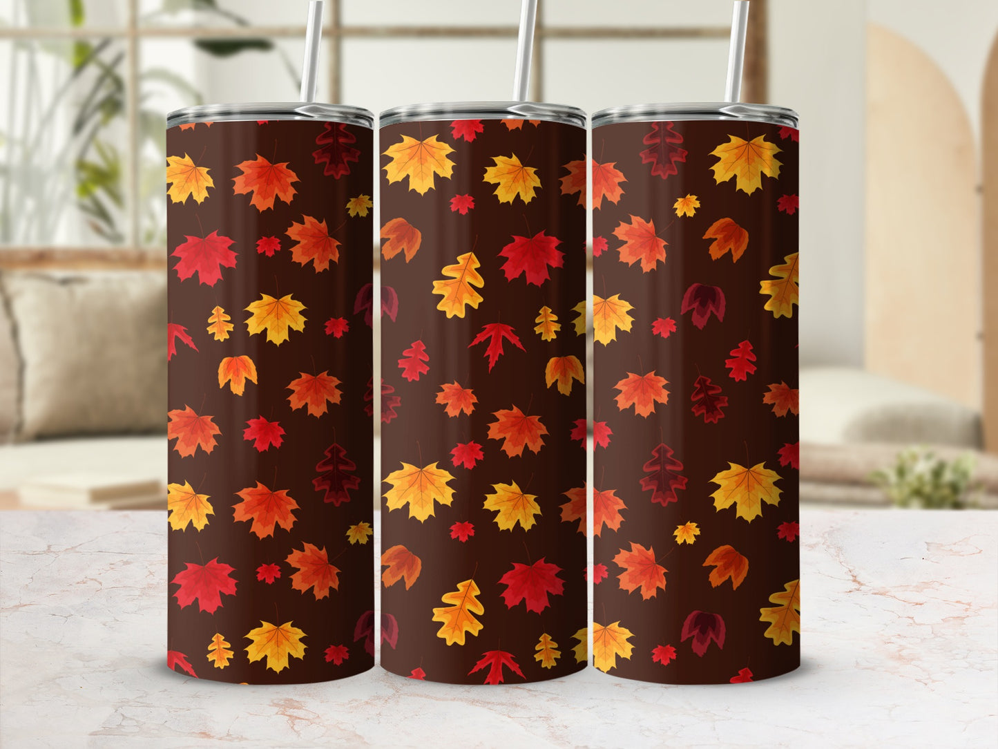 Three tumblers with a repeating pattern of colorful autumn leaves on a dark background.