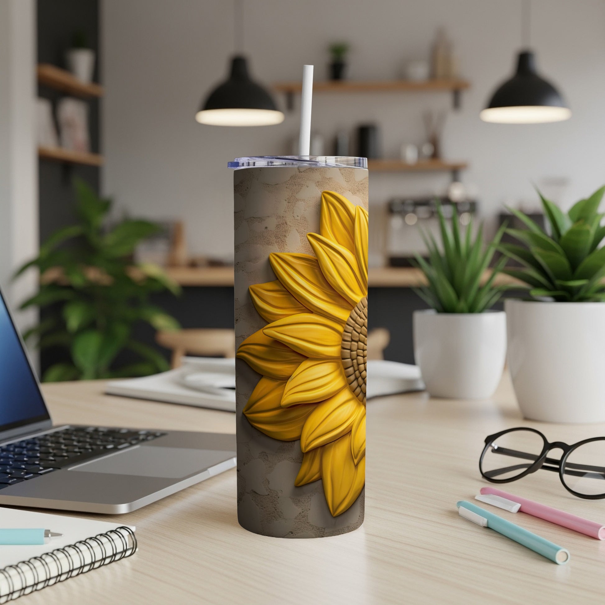Sunflower tumbler with straw on a desk in a home office setting.