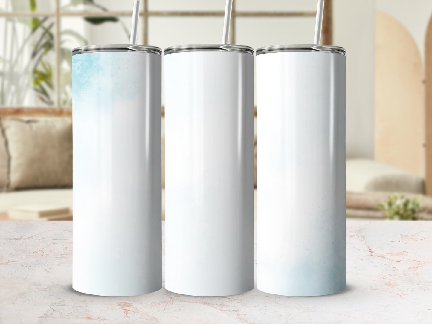 Three white tumblers with blue watercolor accents, displayed on a marble surface.