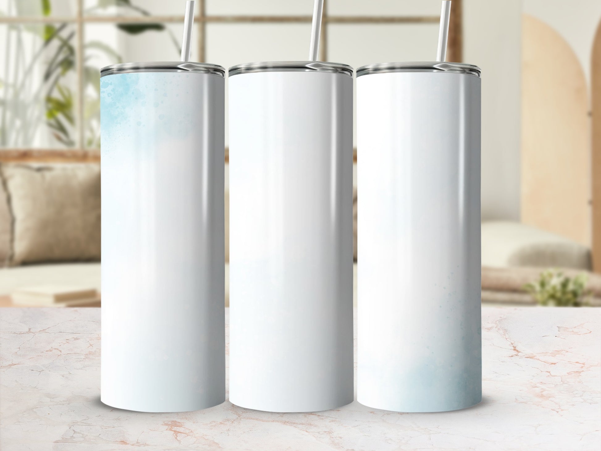 Three white tumblers with blue watercolor accents, displayed on a marble surface.