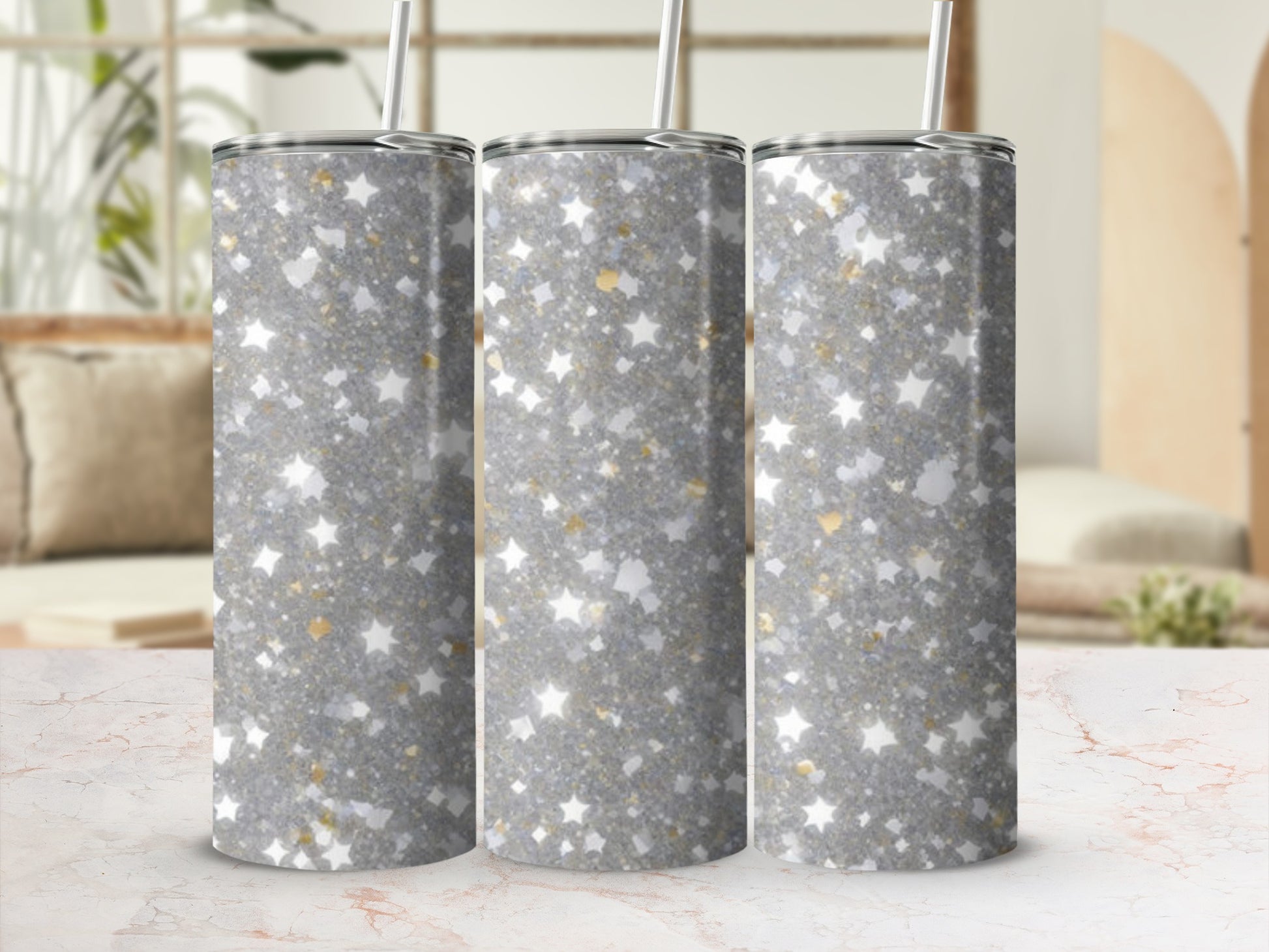 Three sparkly glitter tumblers with star accents on a marble surface.