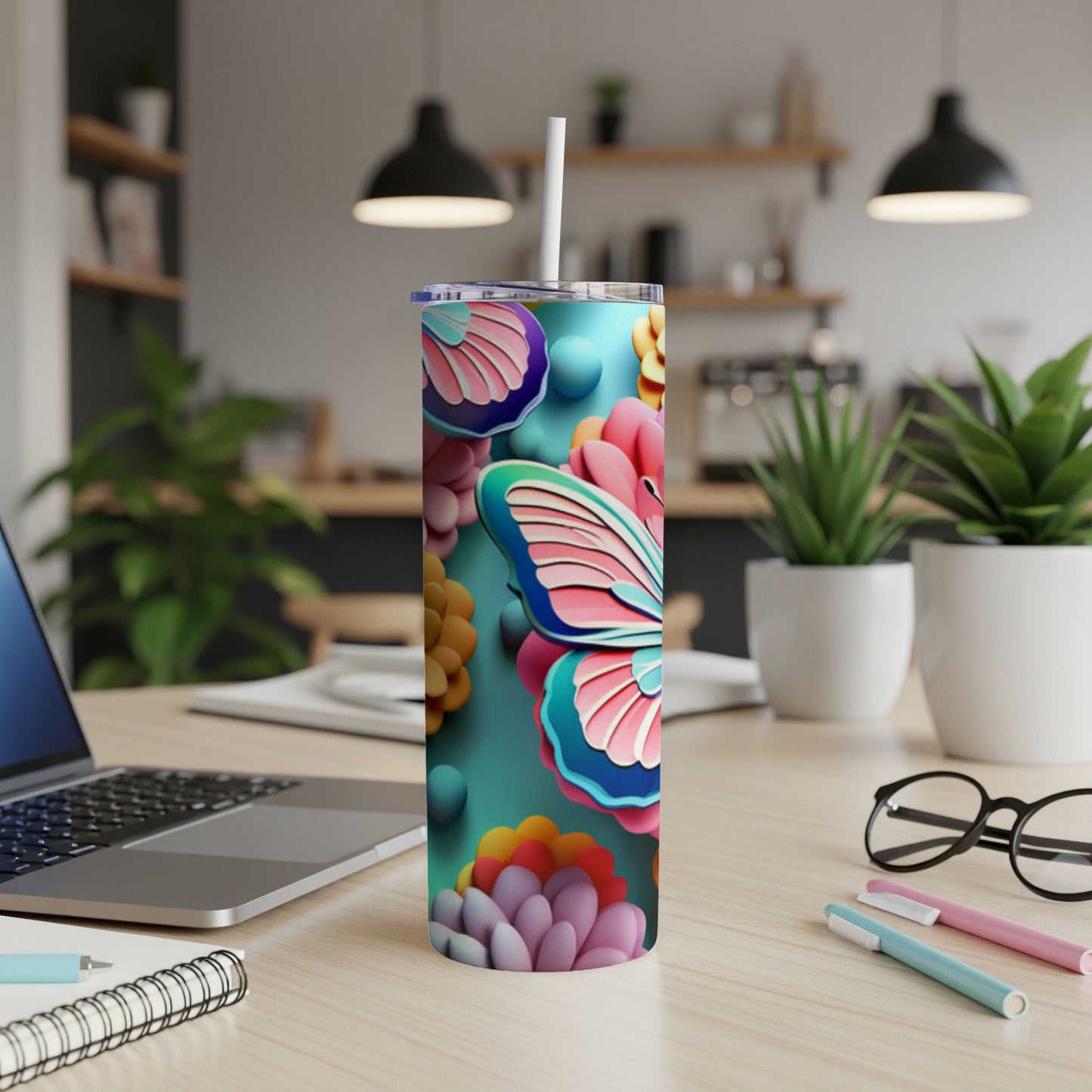 Butterfly and floral design on a teal skinny tumbler with straw.