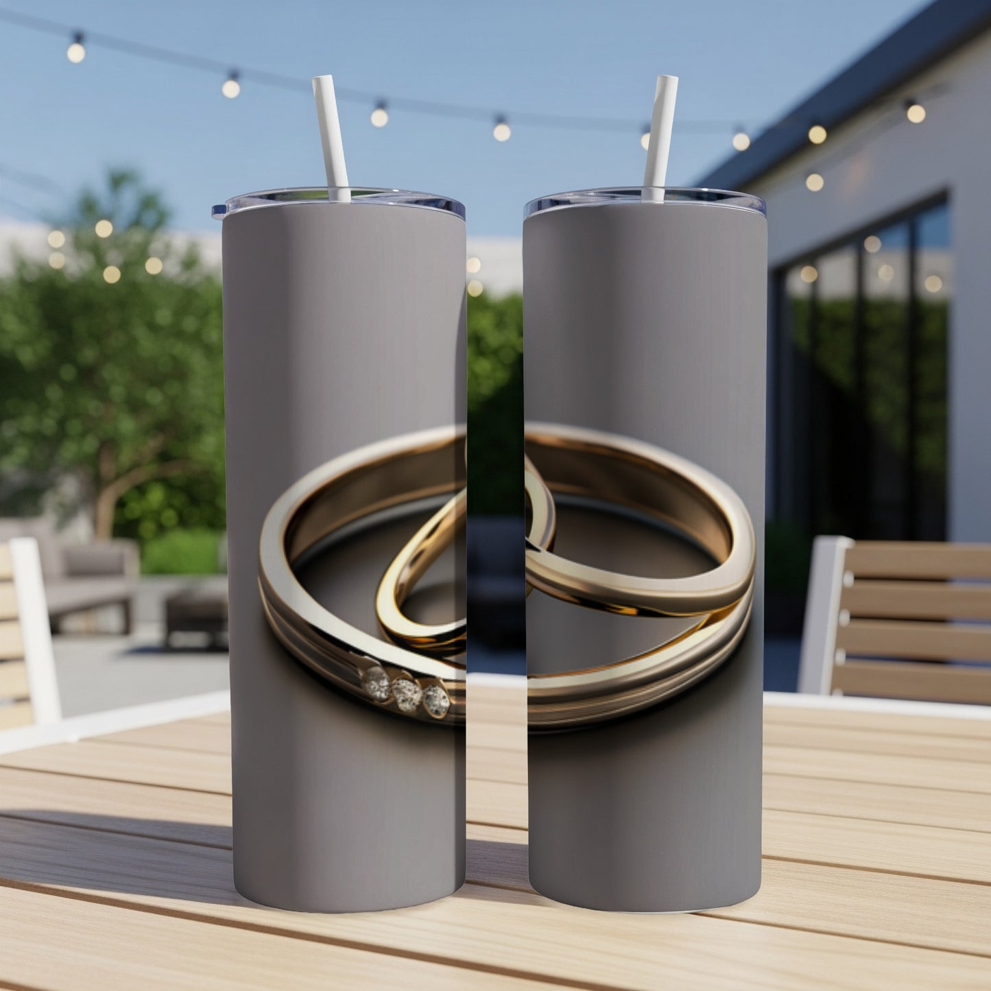 Two silver rings with three small diamonds on a grey tumbler.
