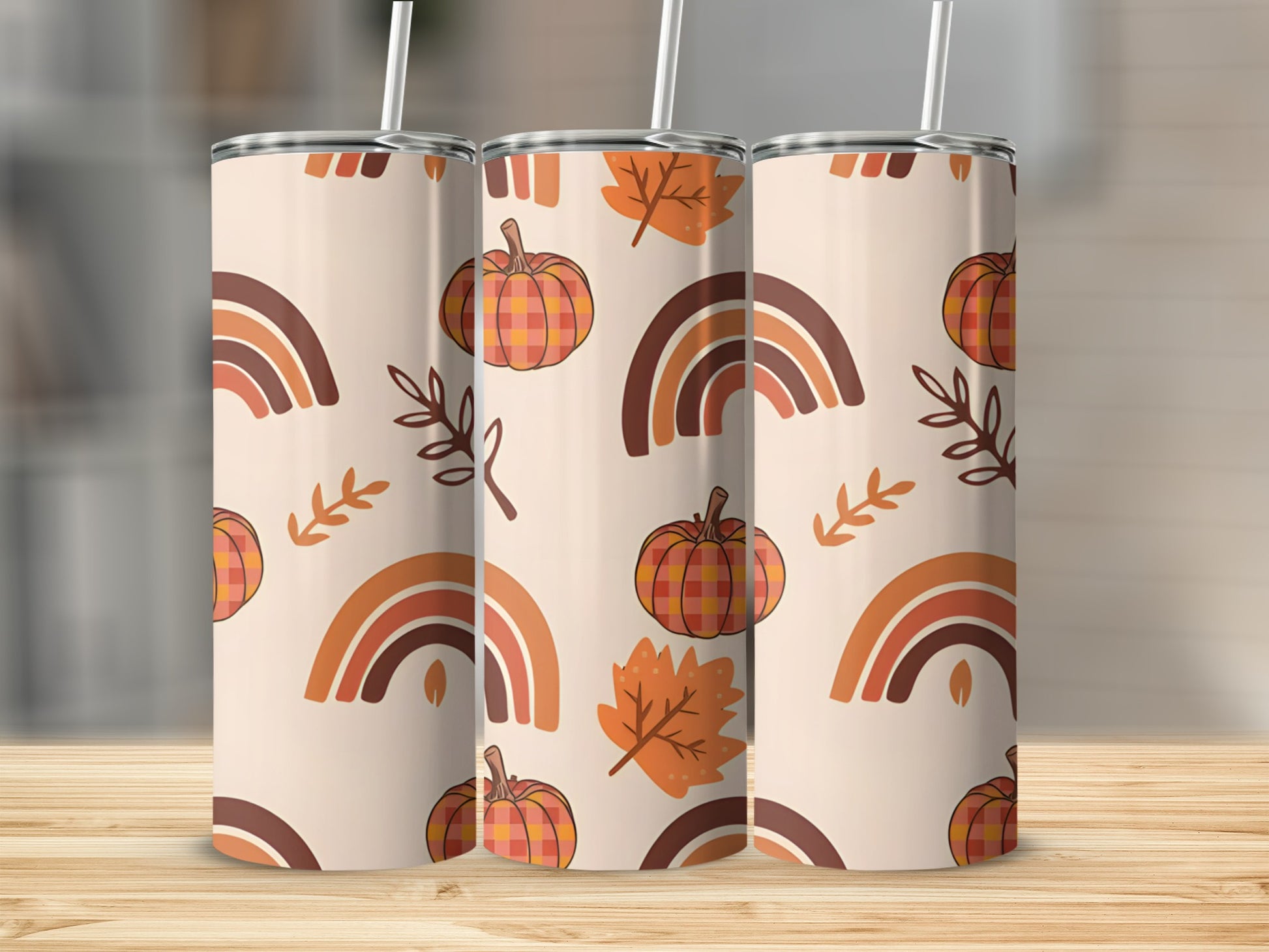 Three tumblers with a fall pattern of pumpkins, leaves, and rainbows.