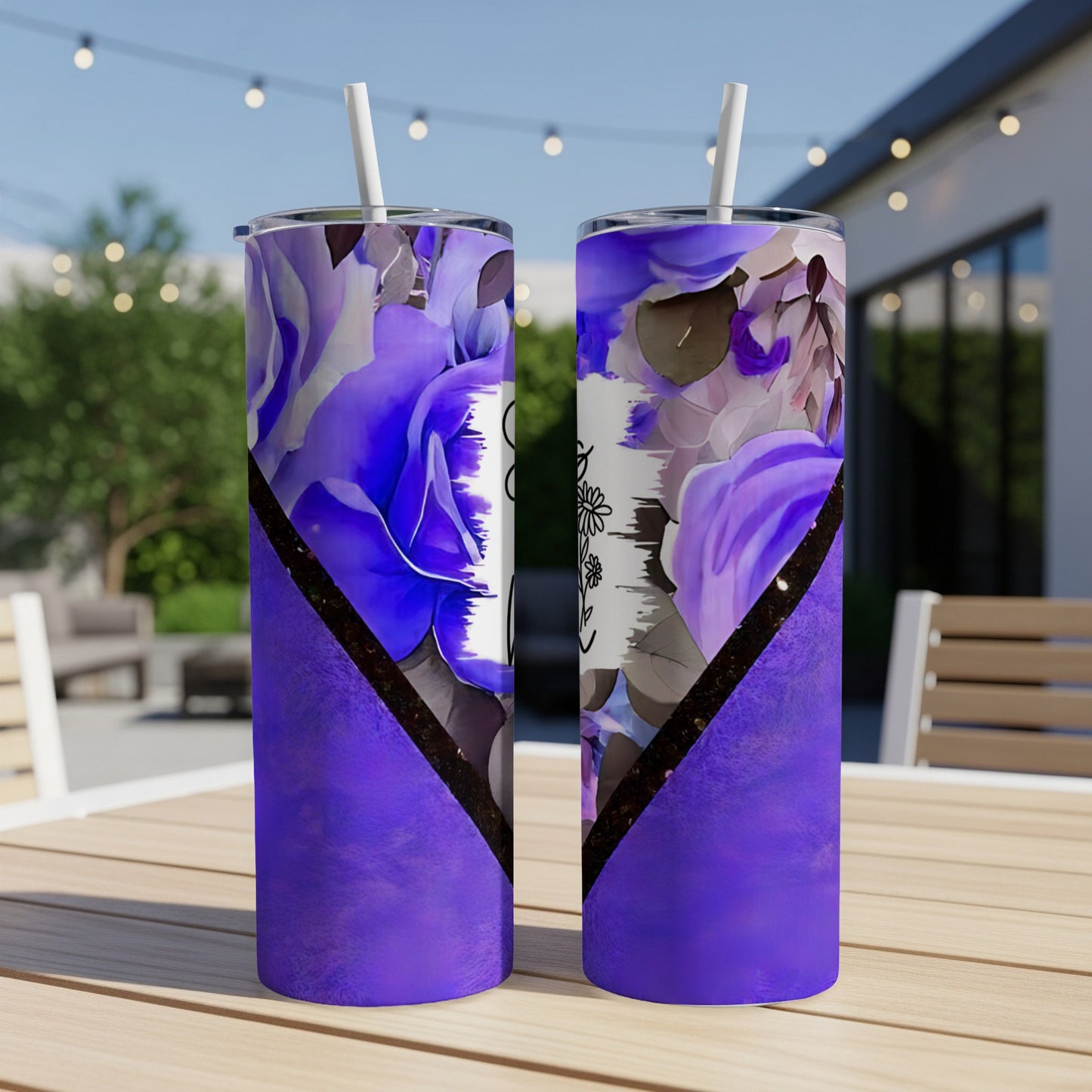 Purple tumbler with floral pattern and white text on outdoor patio table.
