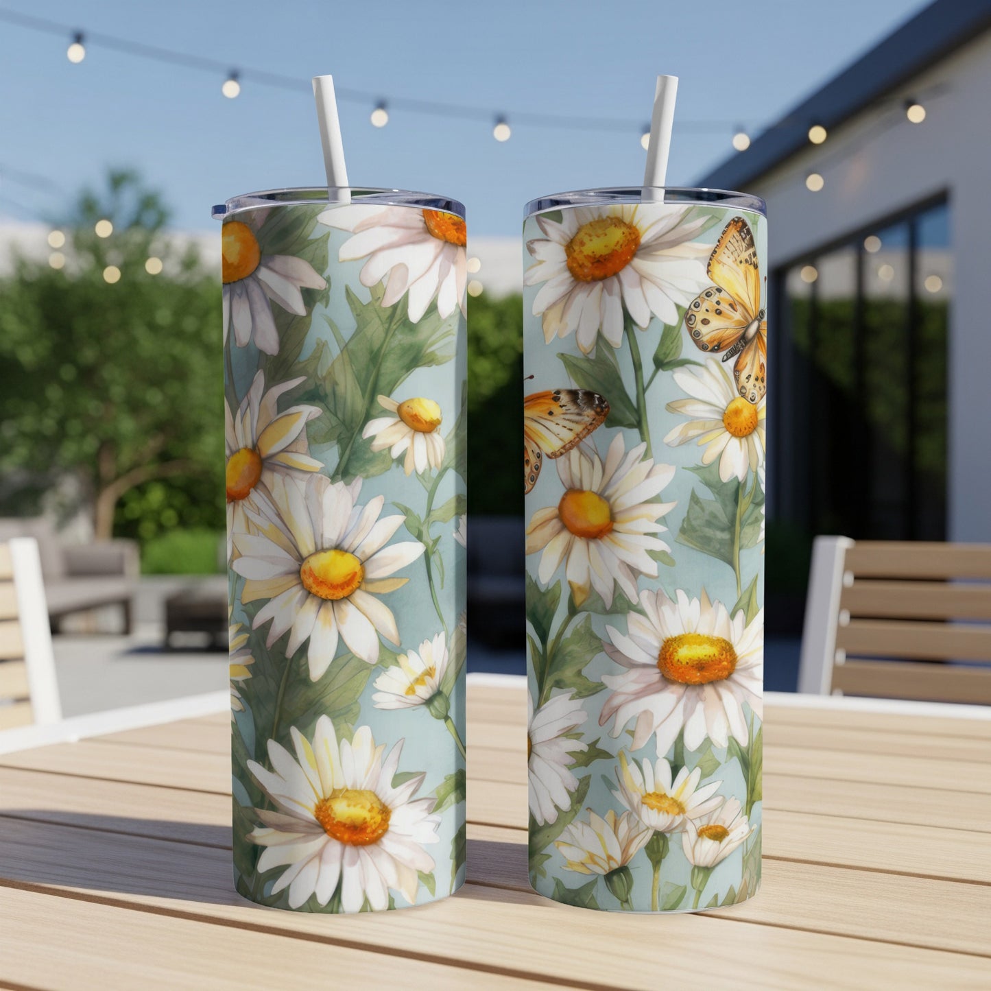 Two tumblers with white daisies and orange butterflies on a light blue background.