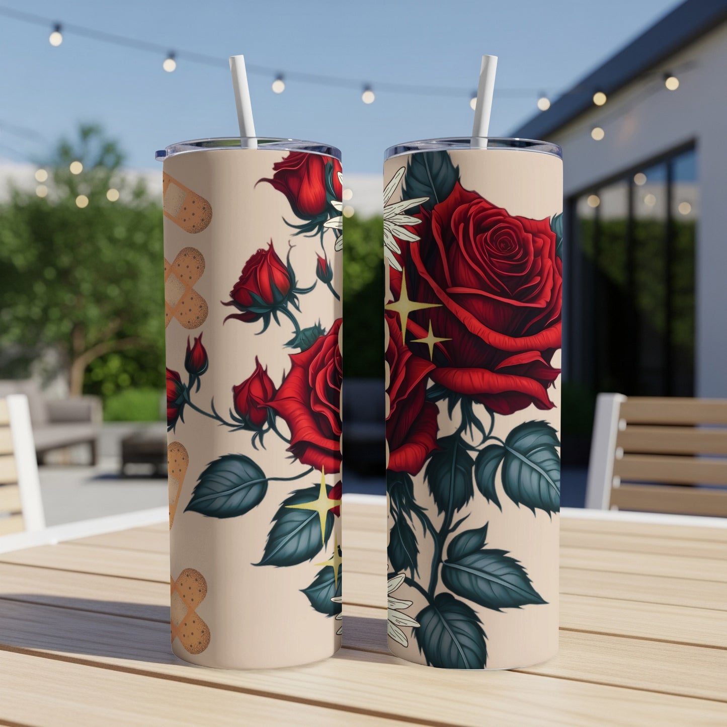 Two tan tumblers with red roses and bandage designs sit on a wooden table.