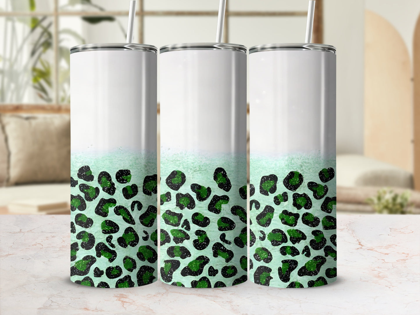 Three tumblers with green leopard print and white tops, shown in a bright setting.