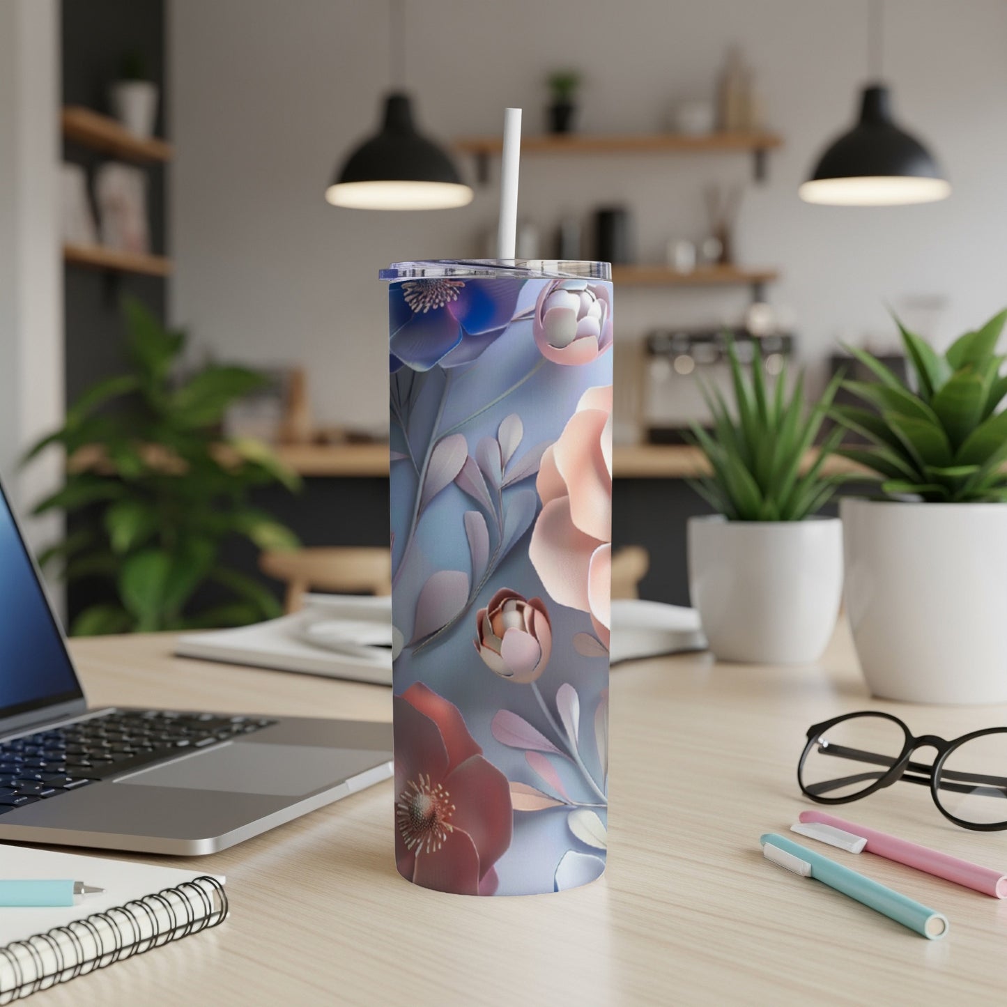 Floral tumbler with lid and straw on a wooden desk.