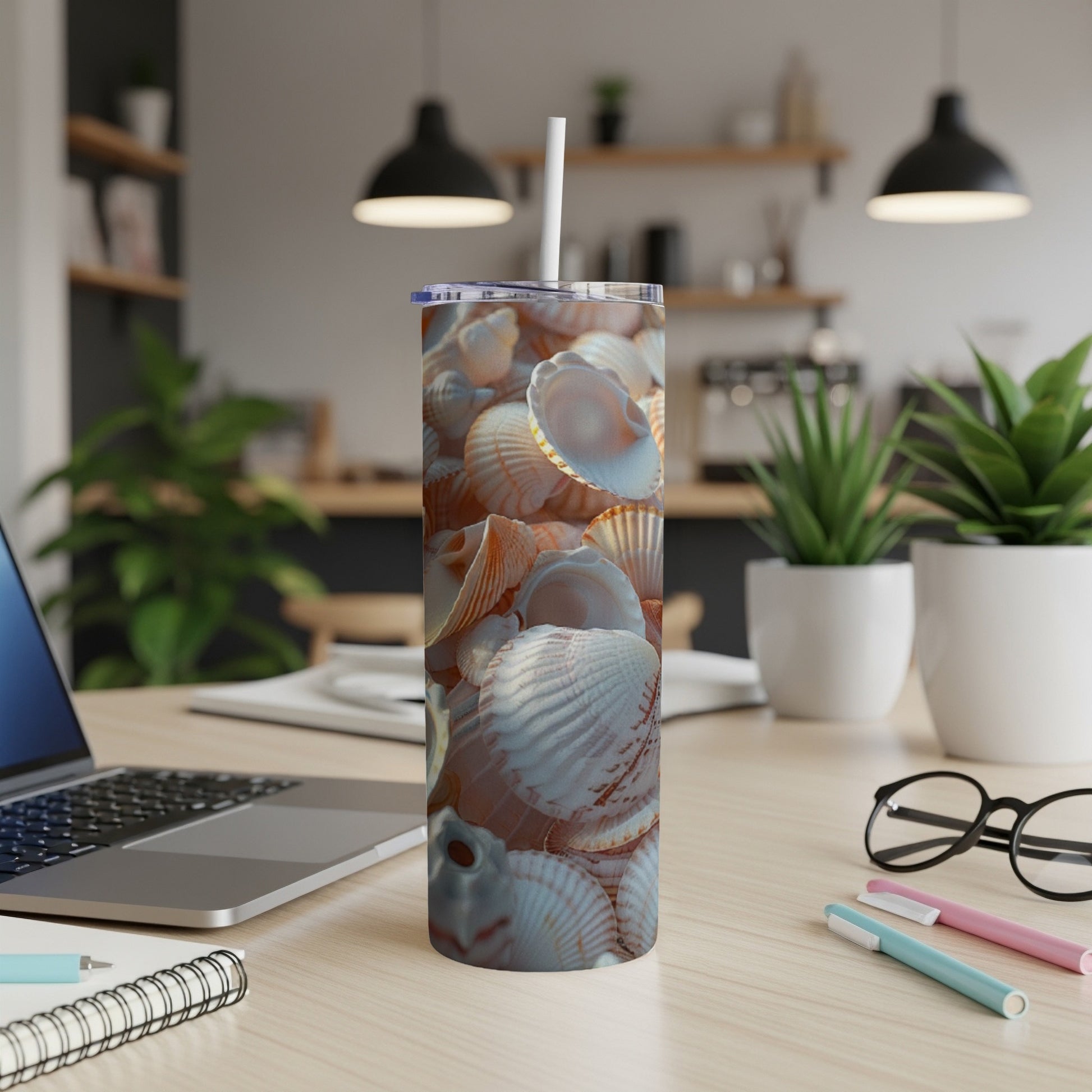 Tumbler cup with realistic seashell pattern on a desk.