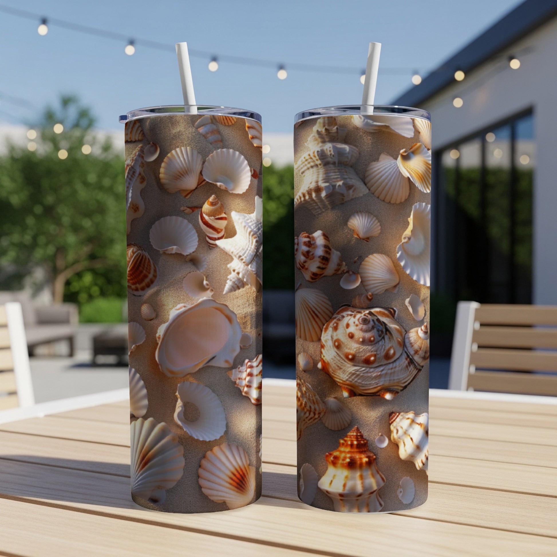 Two tumblers with seashell patterns sit on a table with a blurred outdoor background.