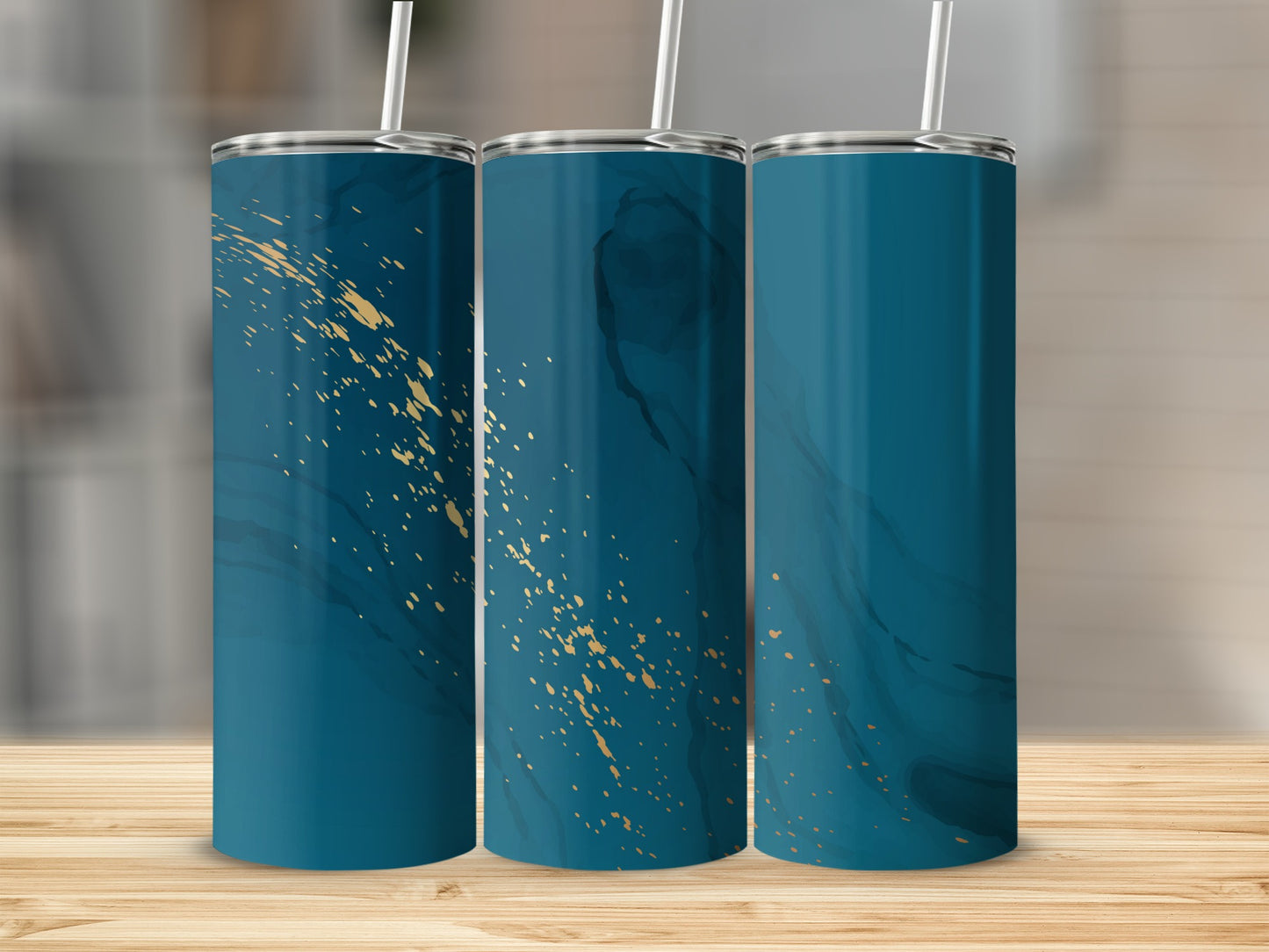 Three teal tumblers with gold speckle pattern on a wooden surface.