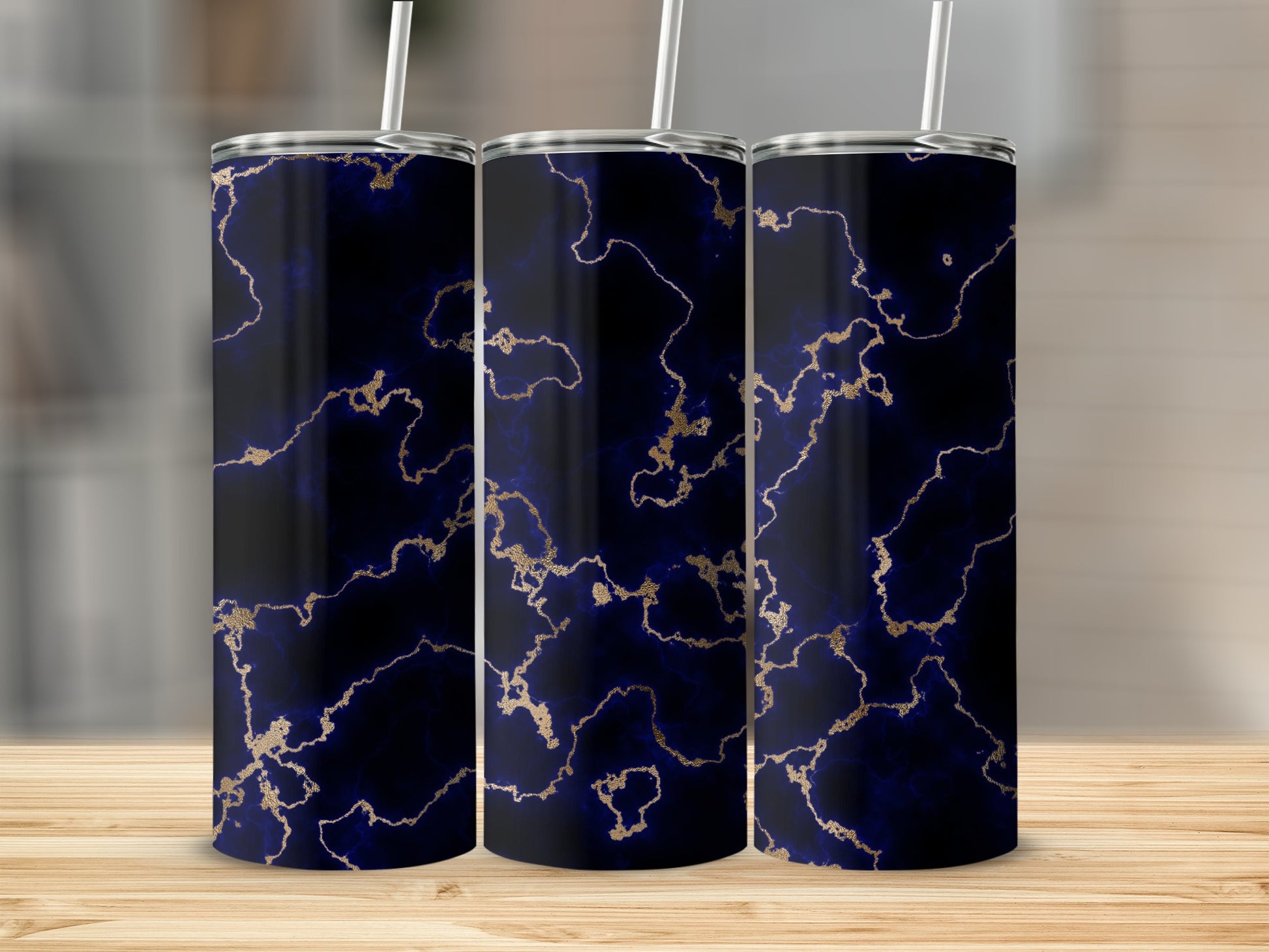 Three navy blue marble pattern tumblers with gold accents and straws.