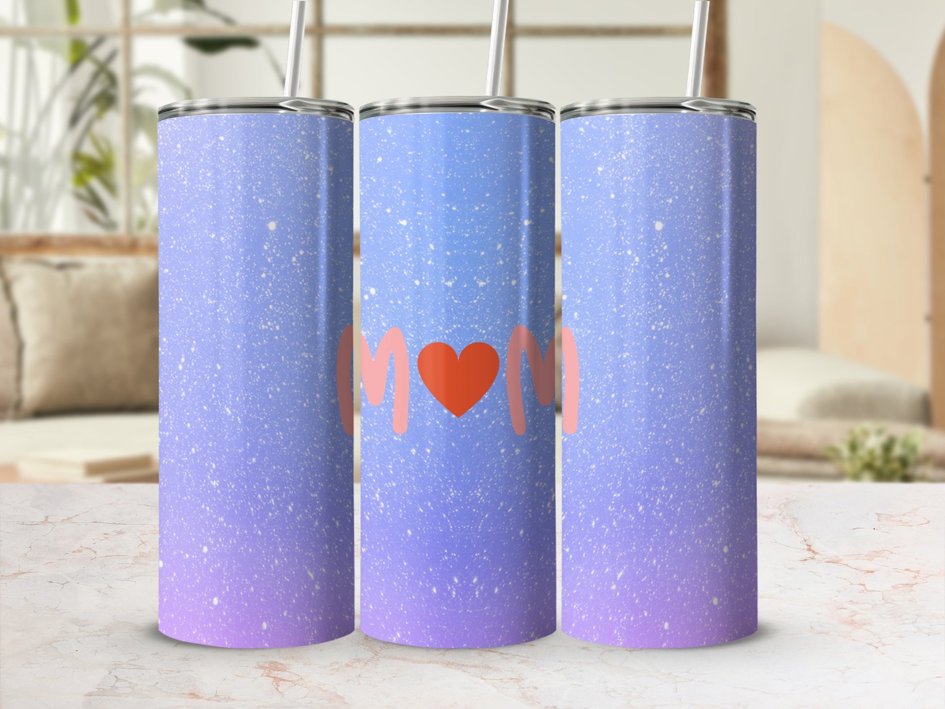 Gradient tumbler with "Mom" in a heart on a blurred background.