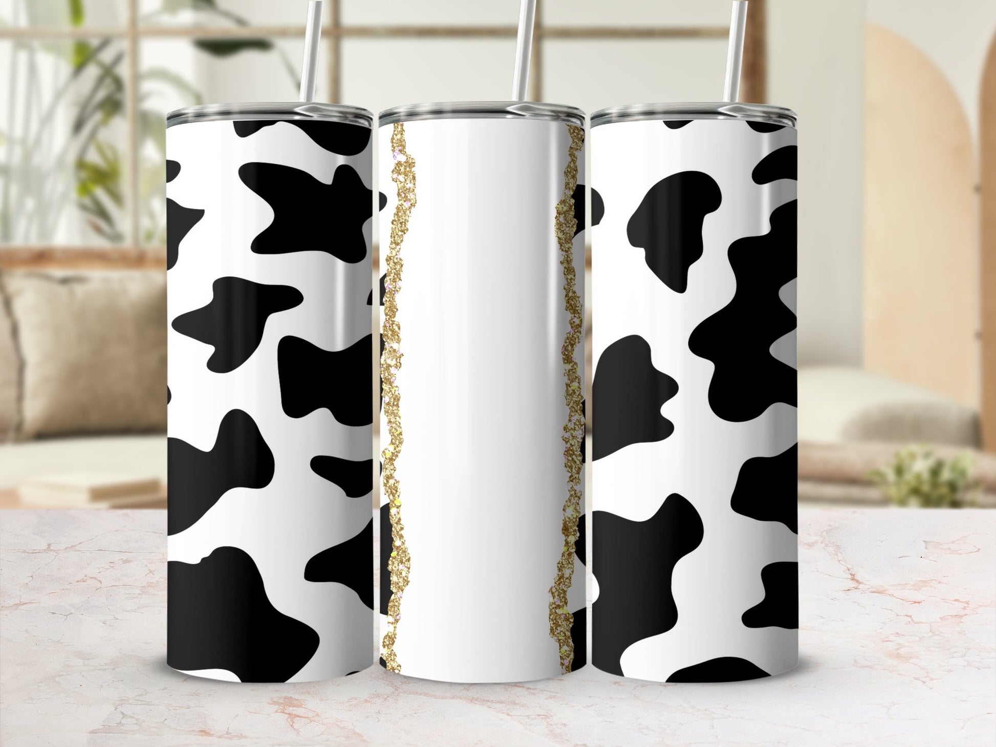 Cow print tumbler with gold glitter accent strip.