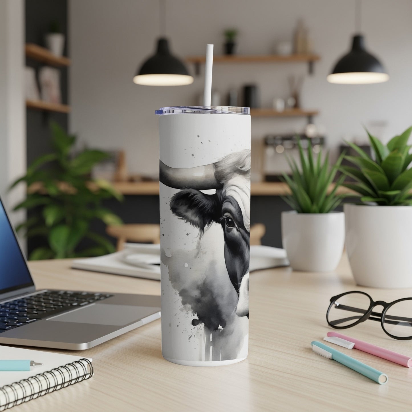 Black and white cow watercolor print on a white tumbler with straw.