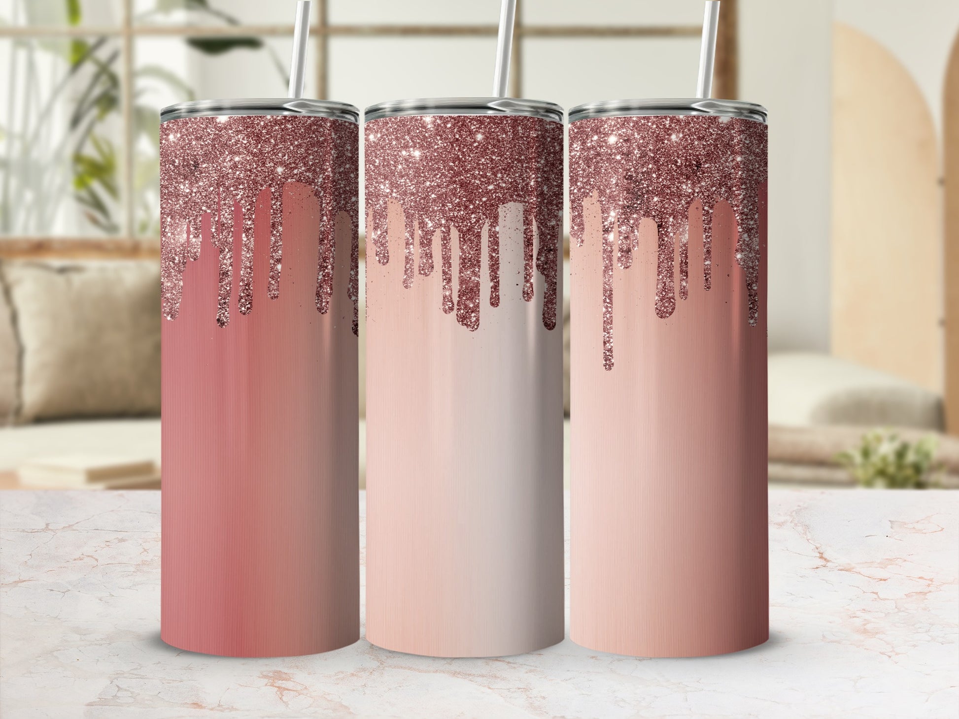 Three rose gold glitter drip tumblers with straws on marble counter