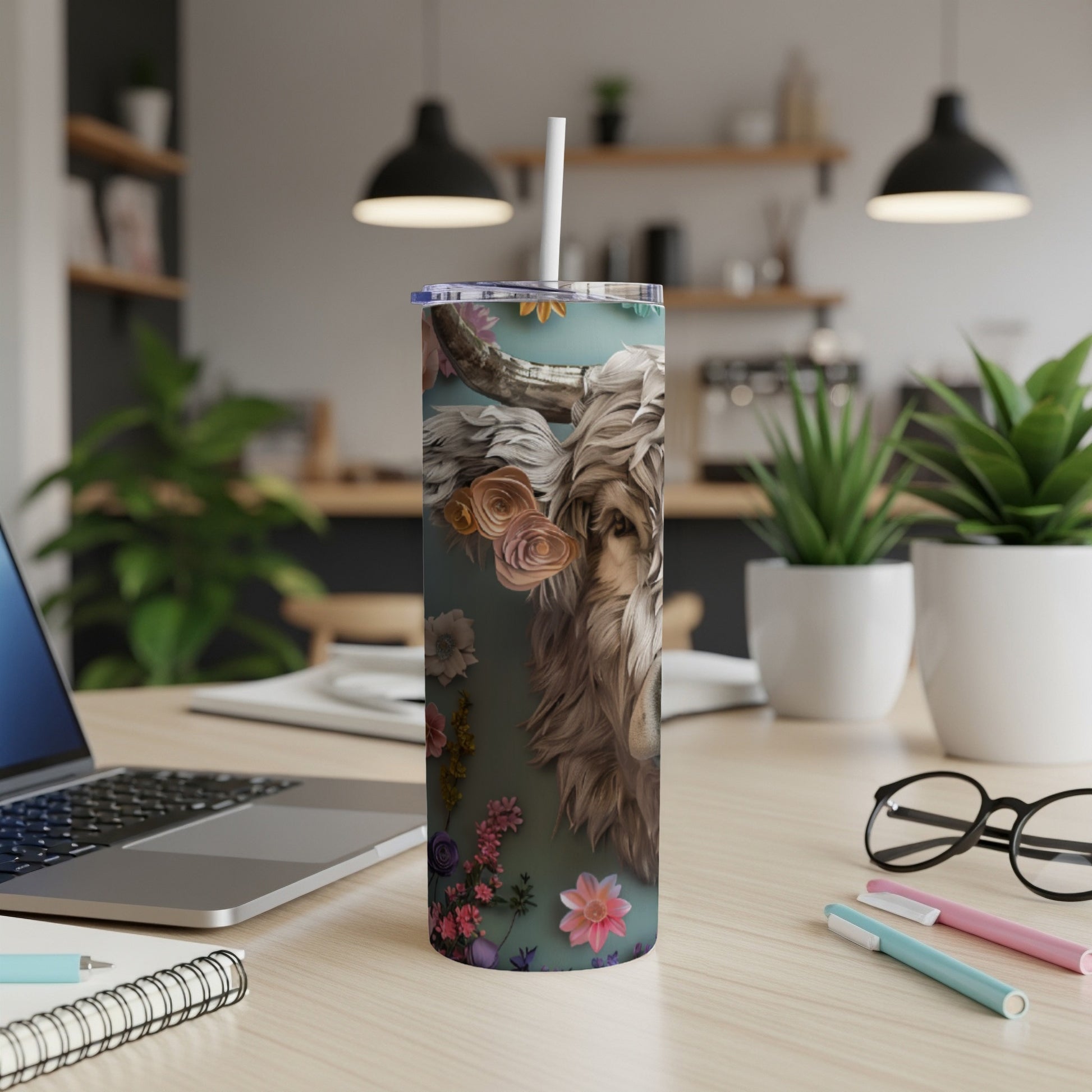 Tumbler with lion and floral design, straw included, on a desk.