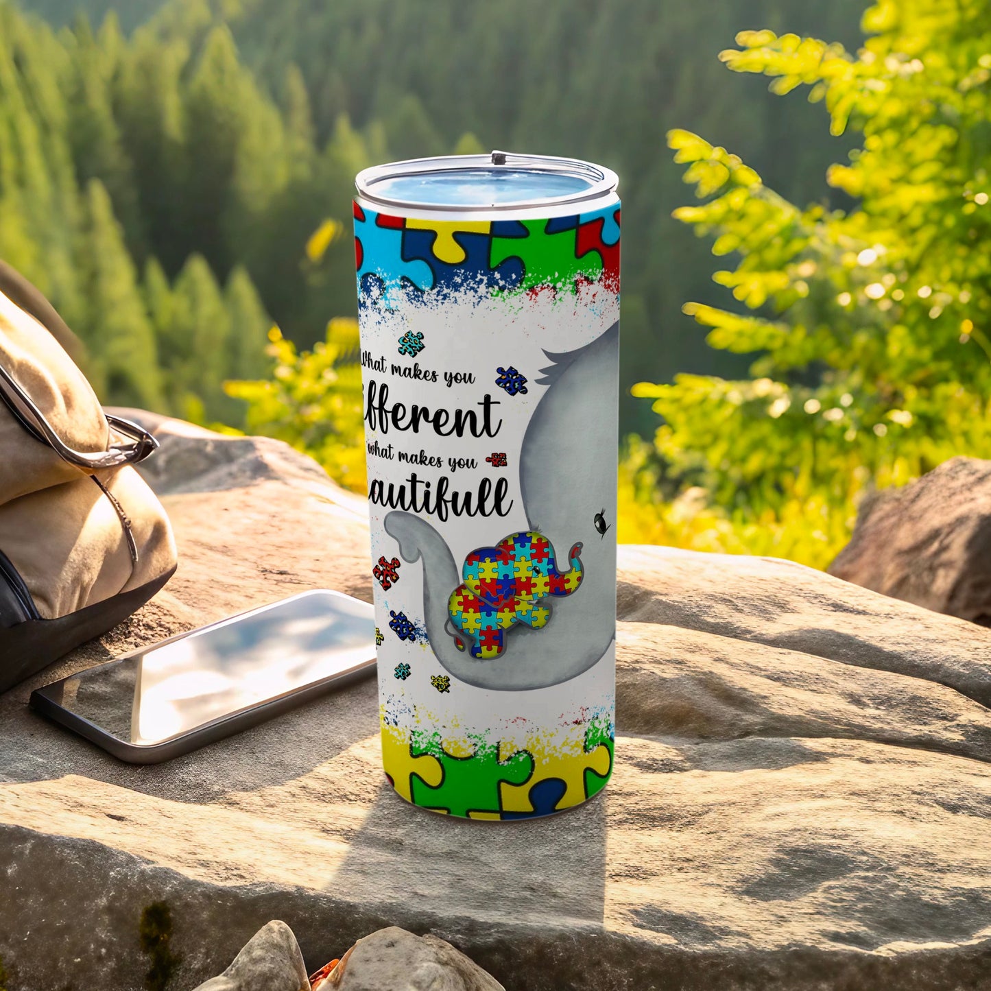 Elephant and puzzle pieces on a tumbler with "What makes you different what makes you beautiful" text.