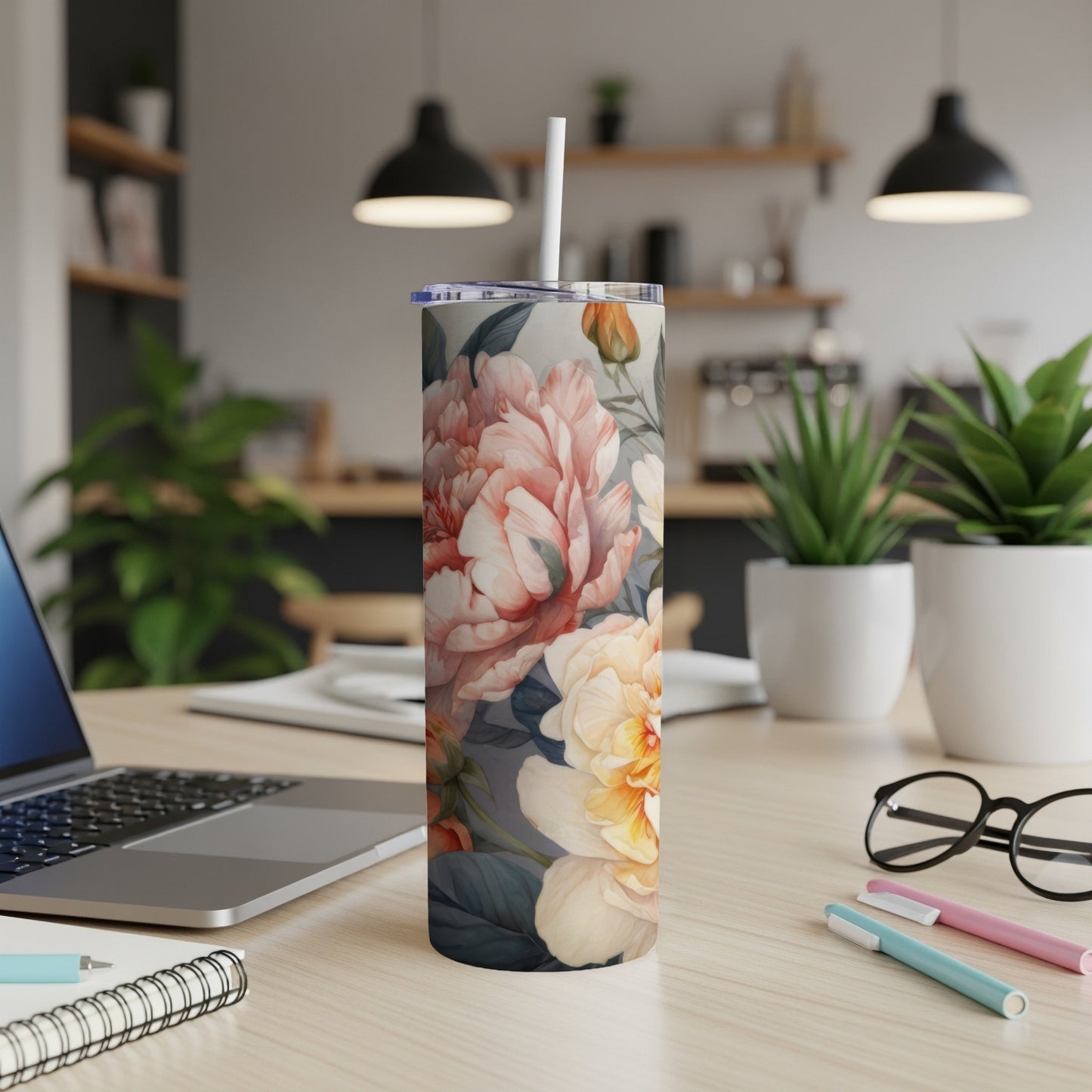 Tall floral tumbler with peonies and roses, lying on a desk.