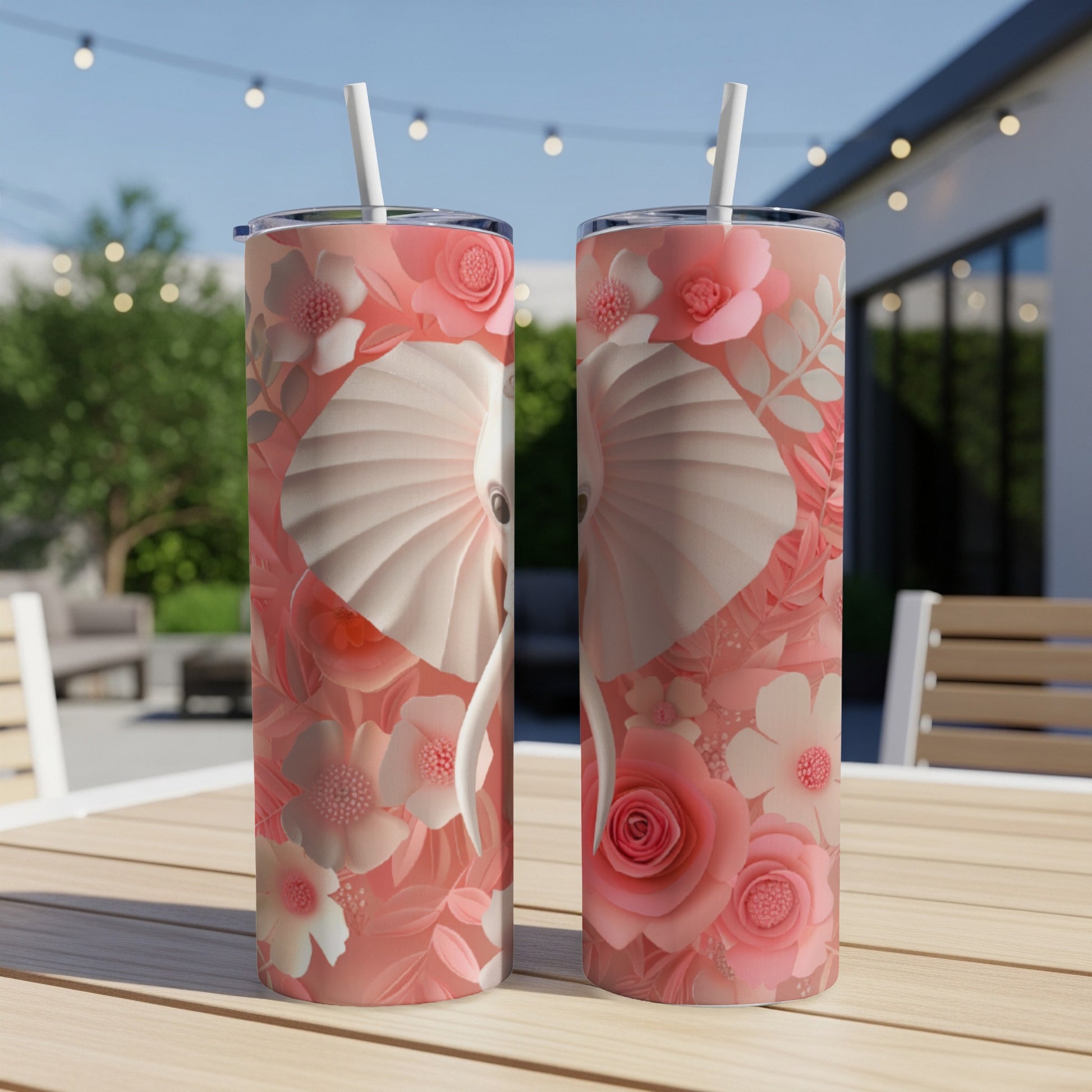 Two pink tumblers with elephant and floral pattern on a table.