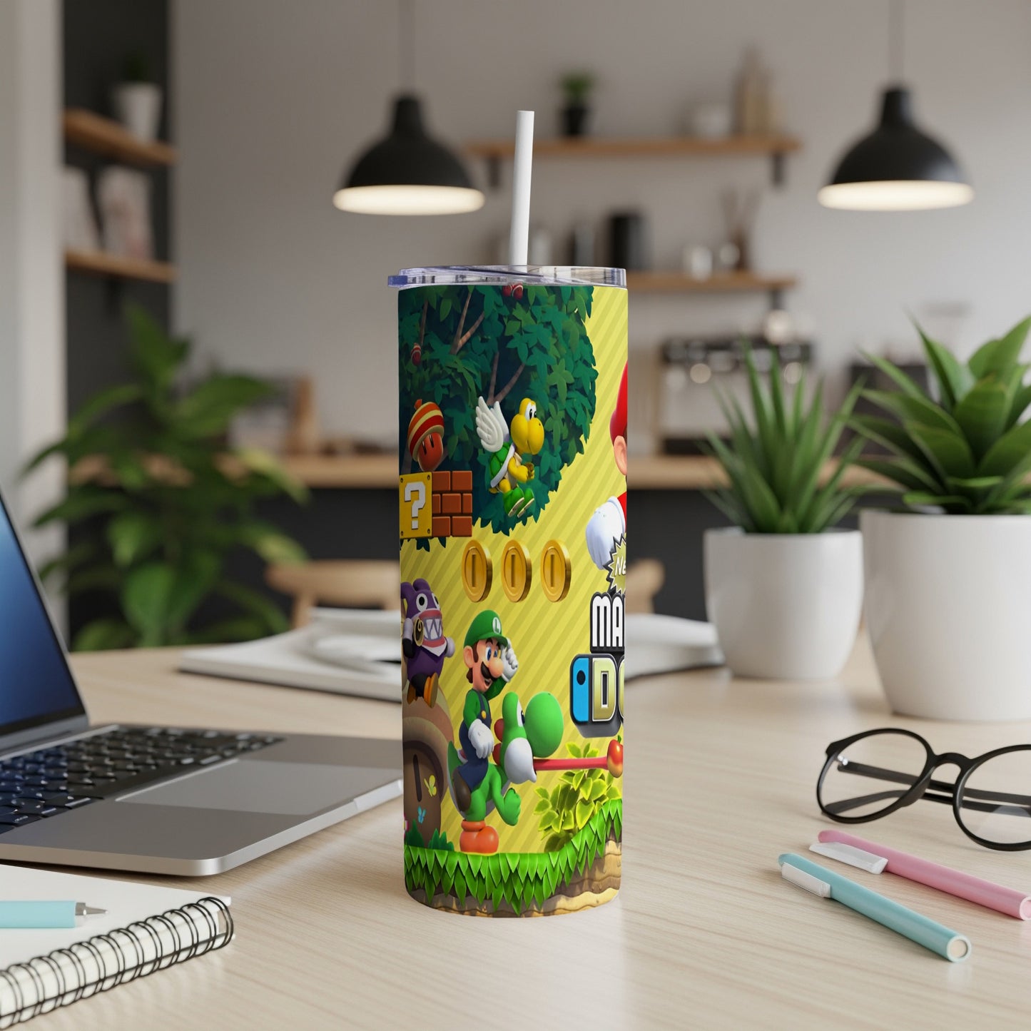 Mario characters on a yellow tumbler with a straw, on a desk.