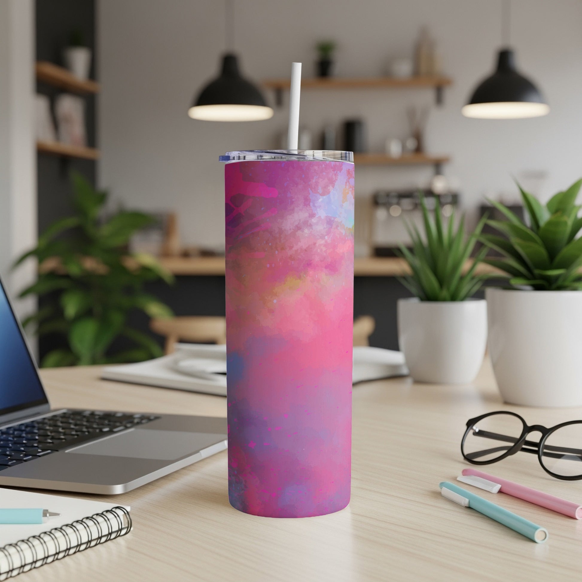 Tumbler with a vibrant pink and blue watercolor splatter design and white straw.
