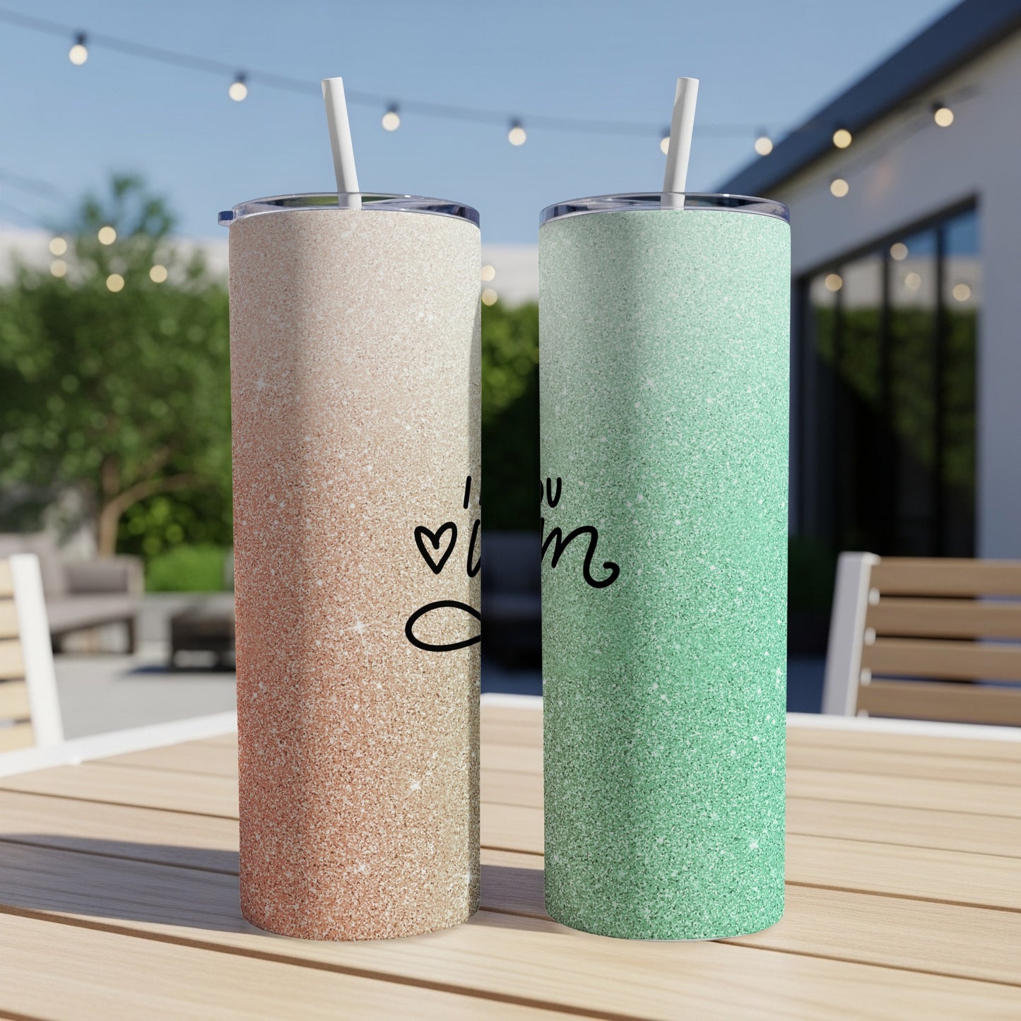 Two glitter tumblers, one rose gold, one mint green, on a table.