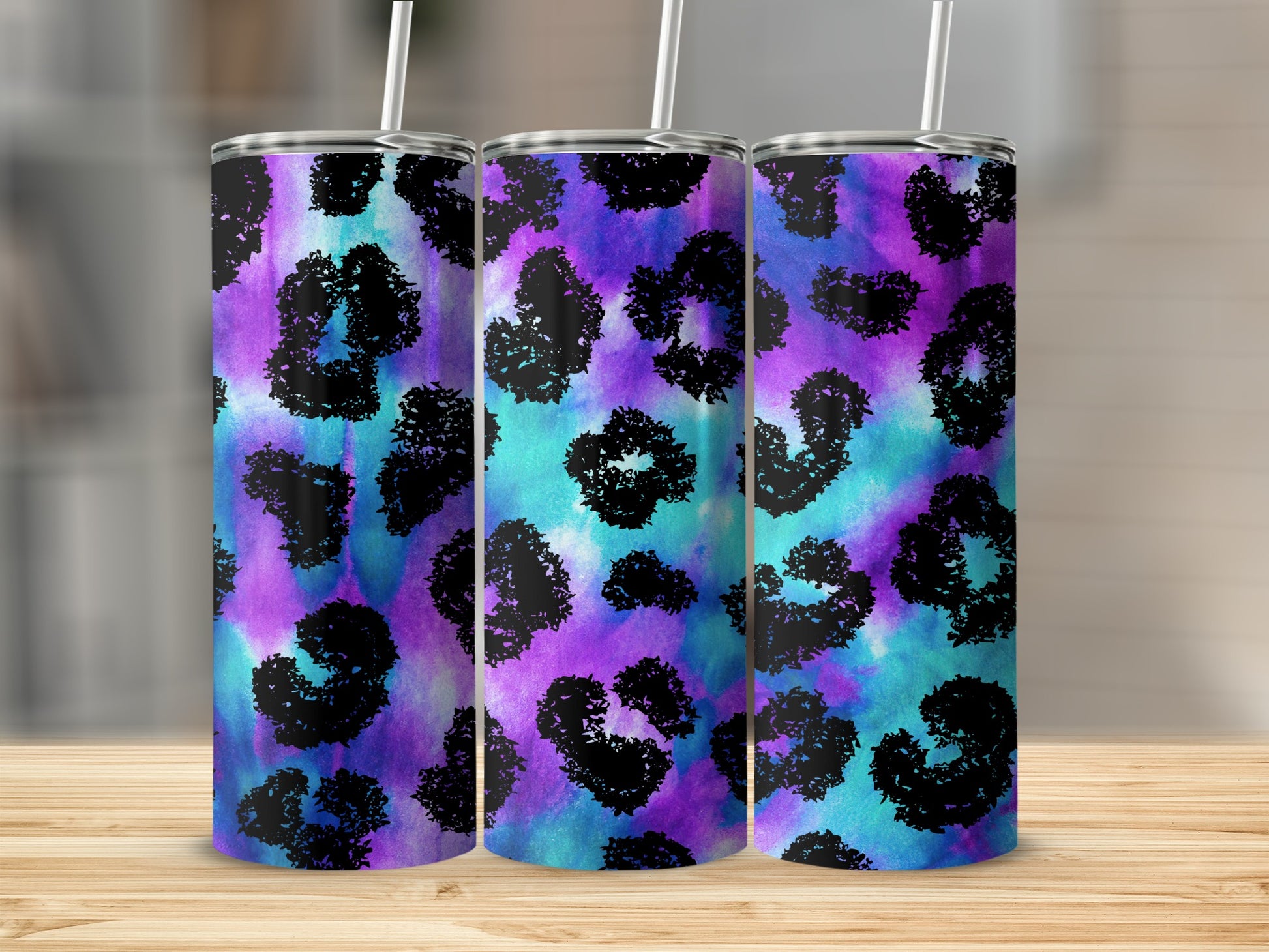 Three tumblers with a purple and teal watercolor leopard print pattern.