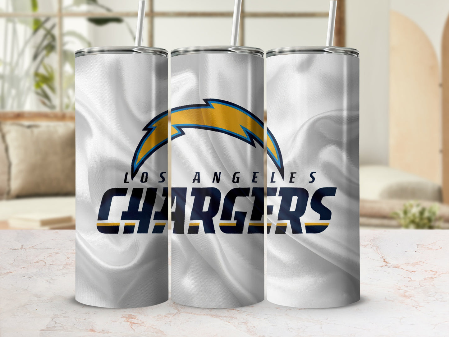 Los Angeles Chargers logo and name on three white tumblers with straws.