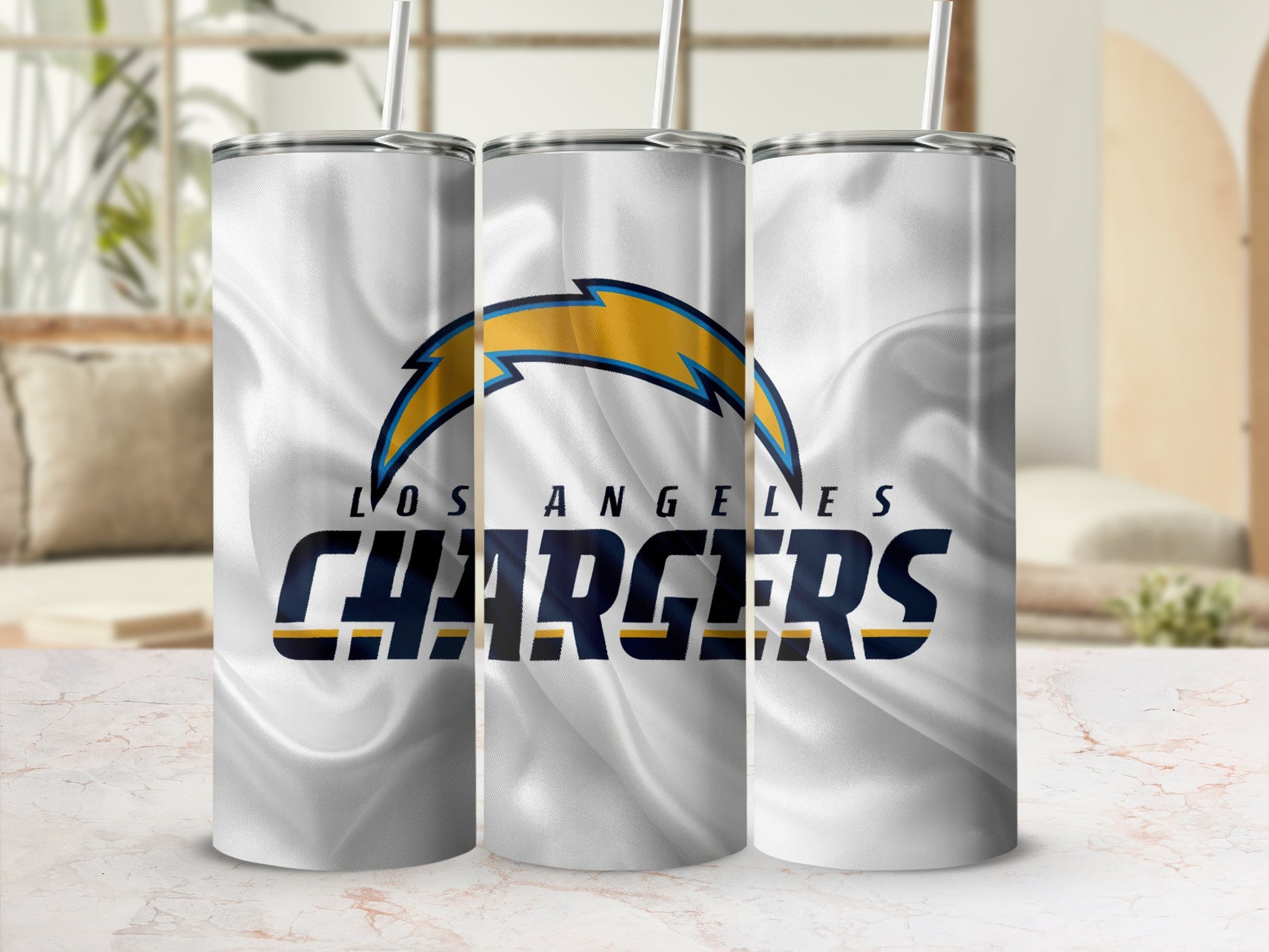 Los Angeles Chargers logo and name on three white tumblers with straws.