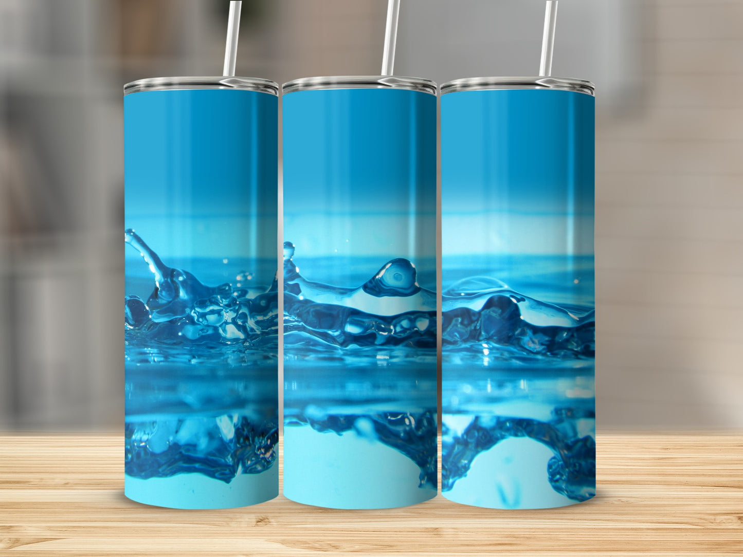 Three tumblers with water splash design, on a wooden surface.