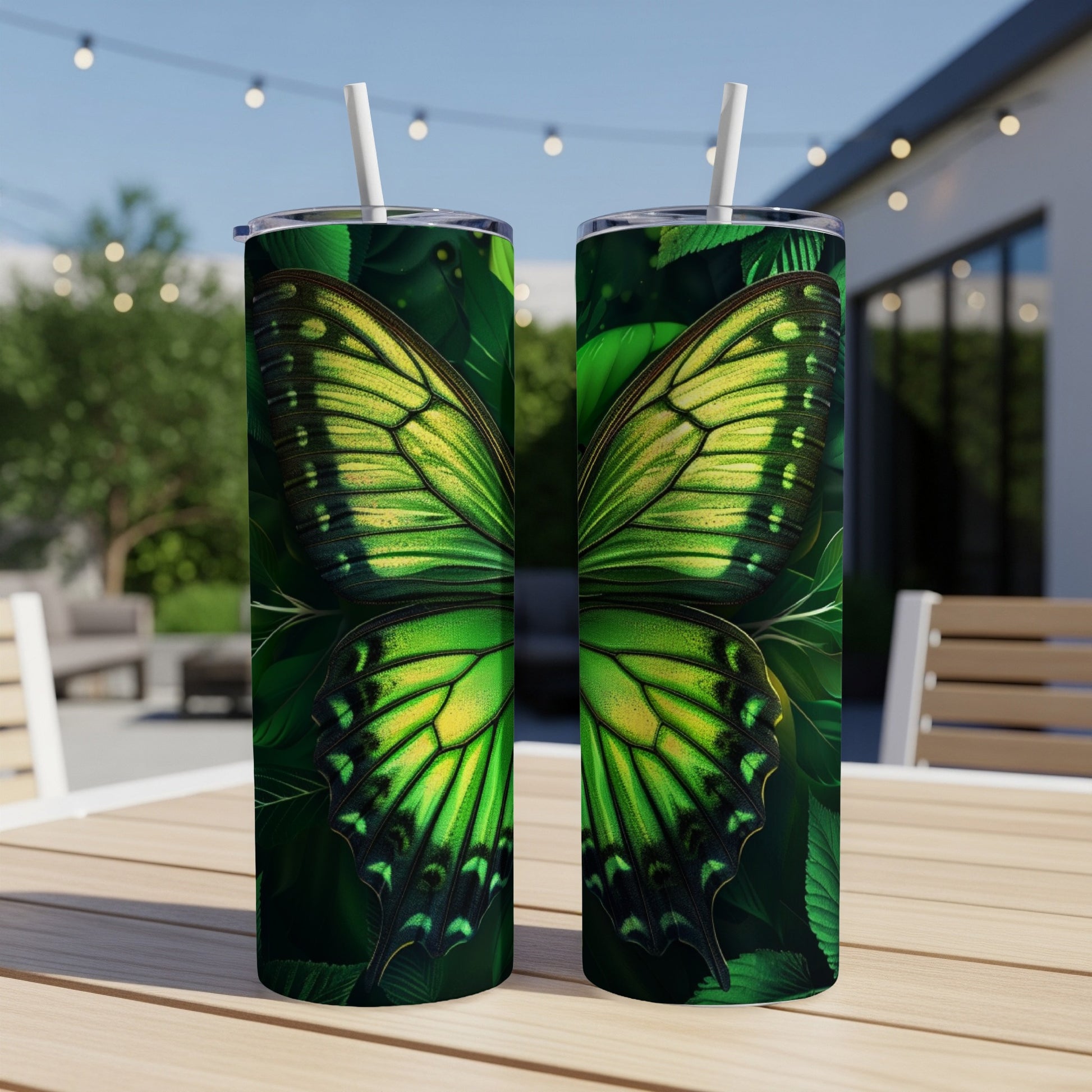Two green butterfly wing patterned tumblers on a wooden table.