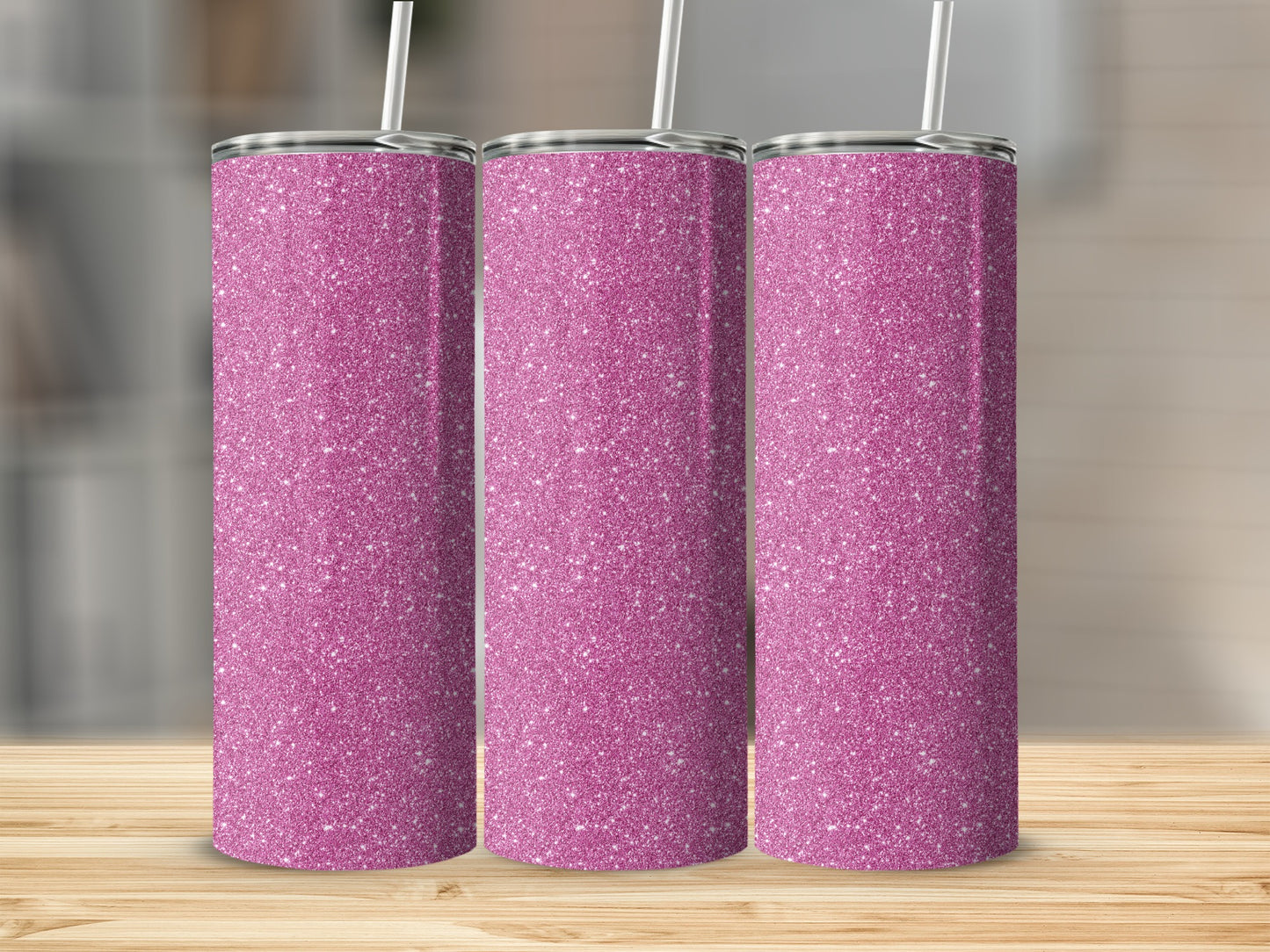 Three pink glitter tumblers with straws stand on a wooden surface.