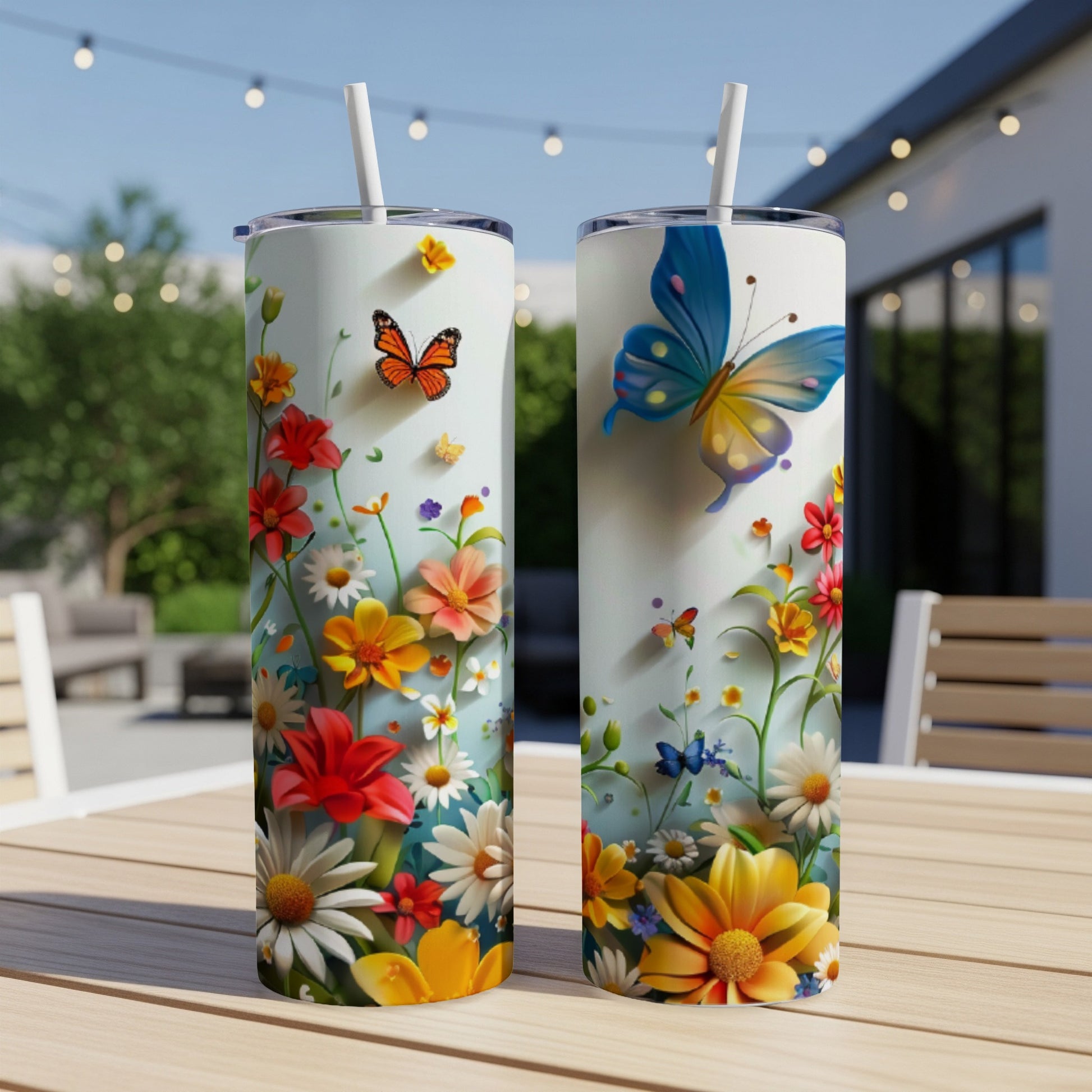 Two tumblers with floral and butterfly designs sit on a table.