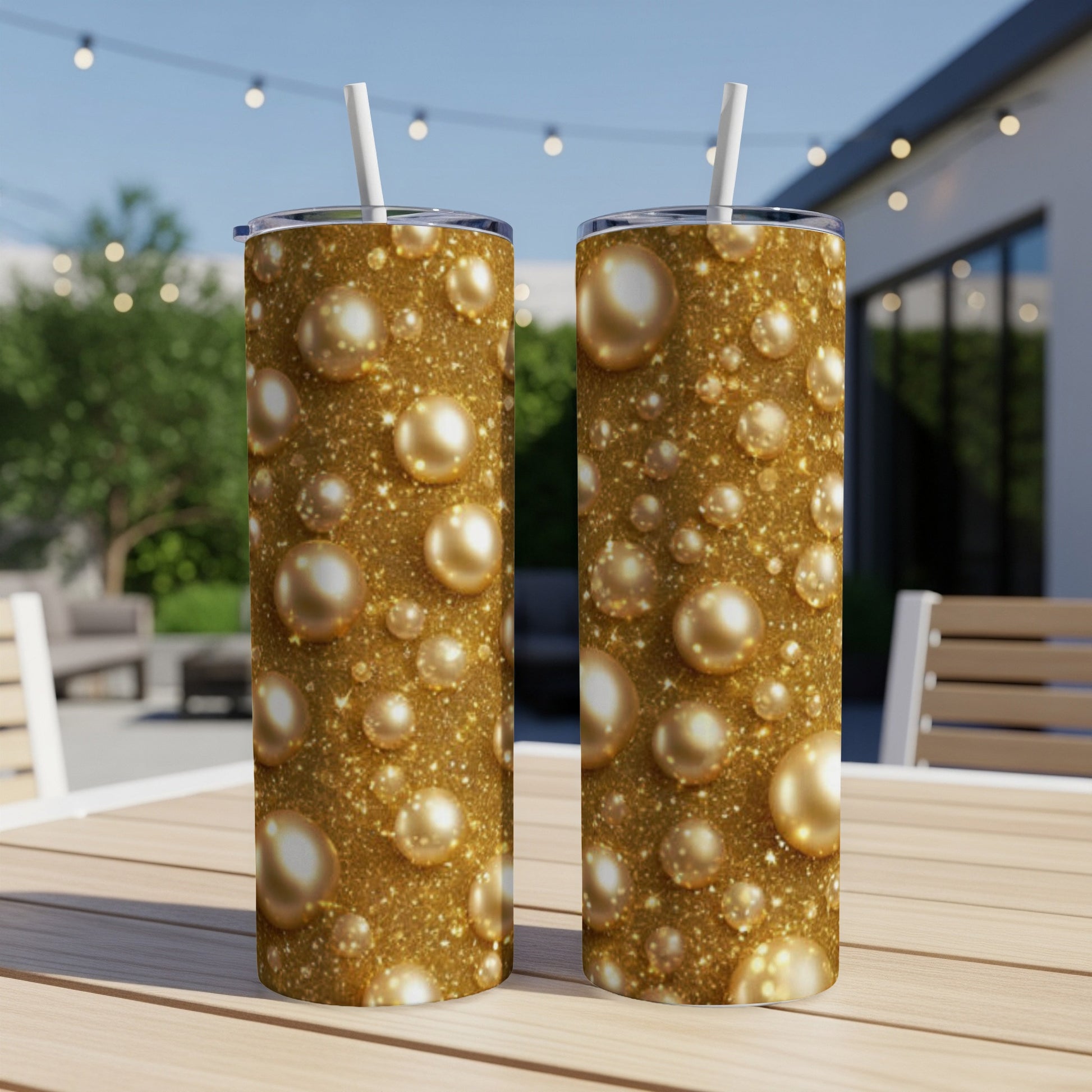 Two gold tumblers with a bubbly, sparkling pattern on a table.