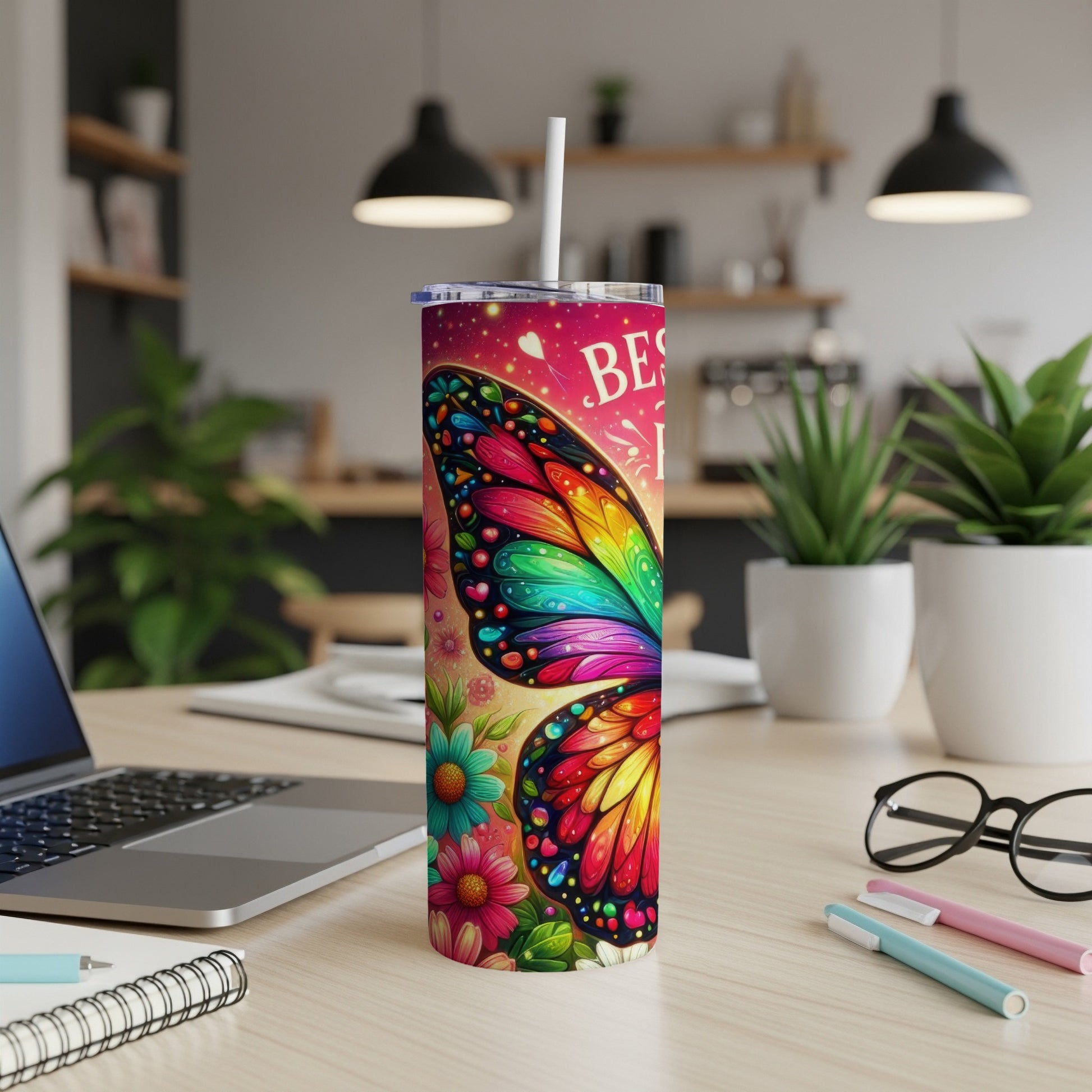 Colorful butterfly tumbler with "BEST..." text on a desk.