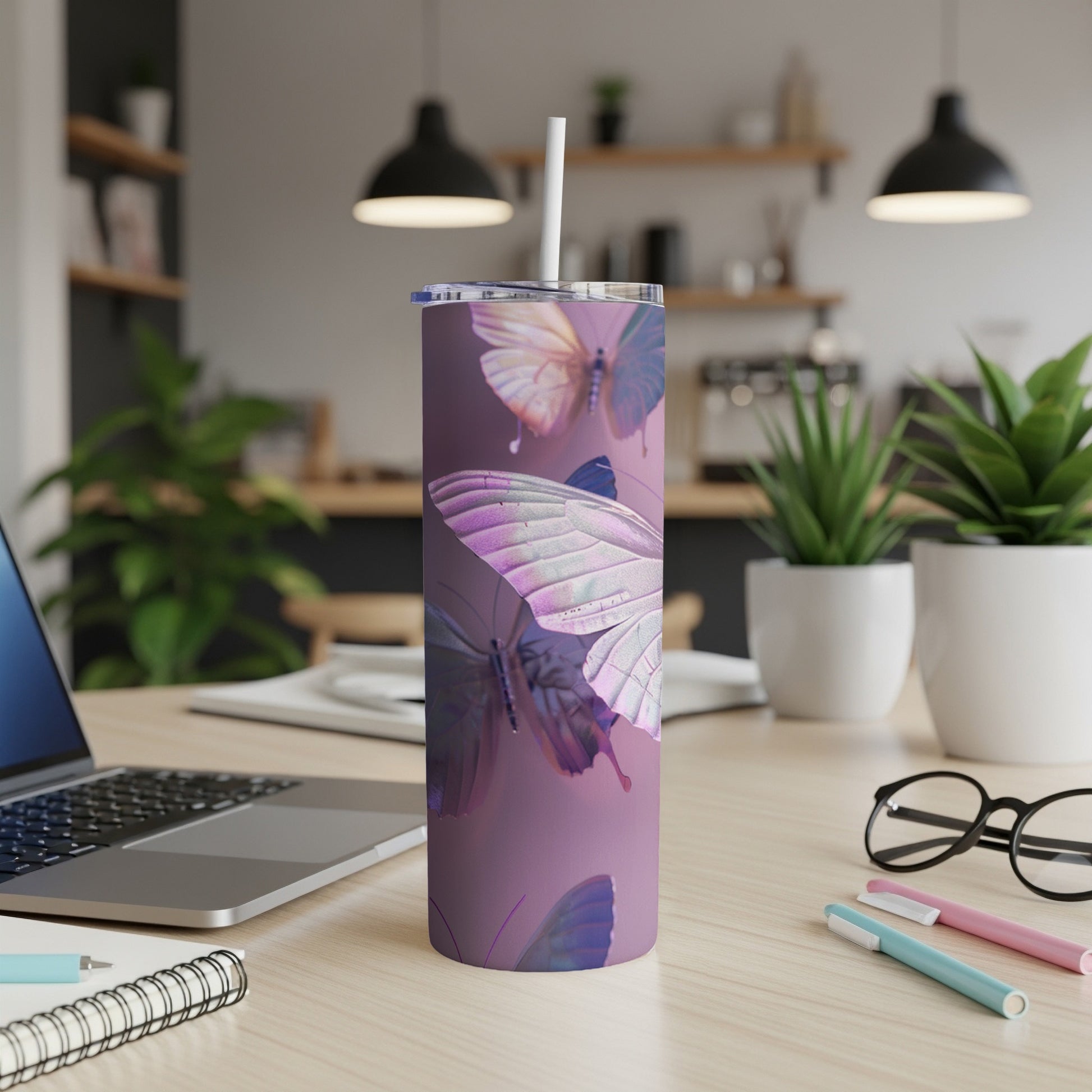 Purple tumbler with iridescent butterfly designs on a desk.