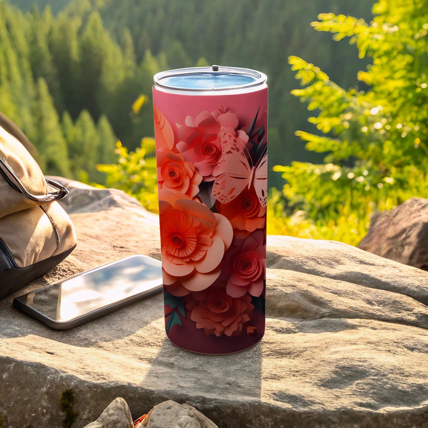 Tumbler with floral and butterfly design on an outdoor table.