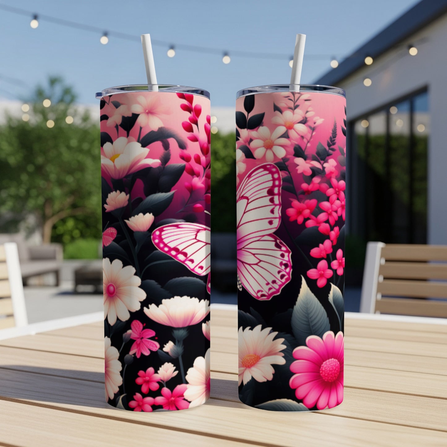 Two tall tumblers with pink floral and butterfly designs on a wooden table.