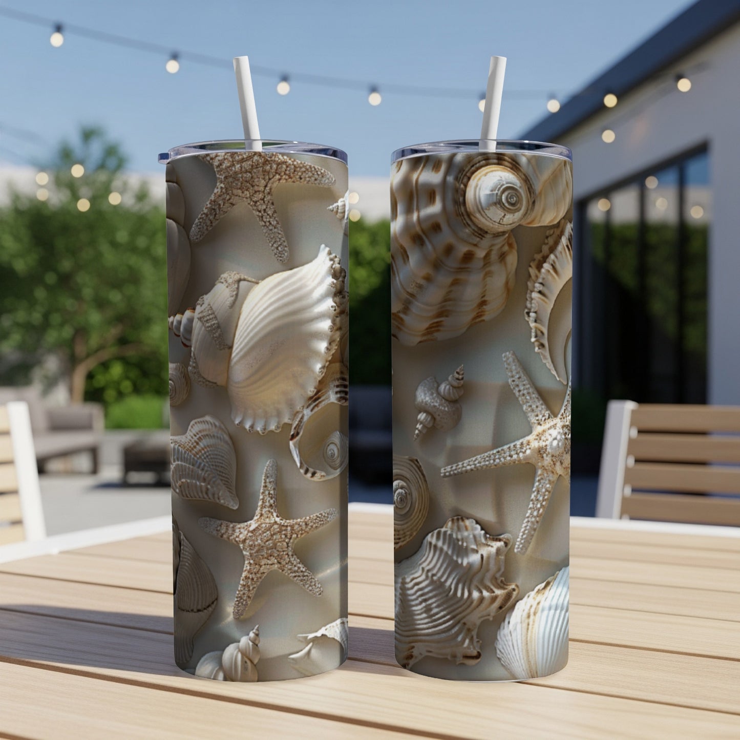 Two tall tumblers featuring a seashell and starfish pattern on a wooden table.