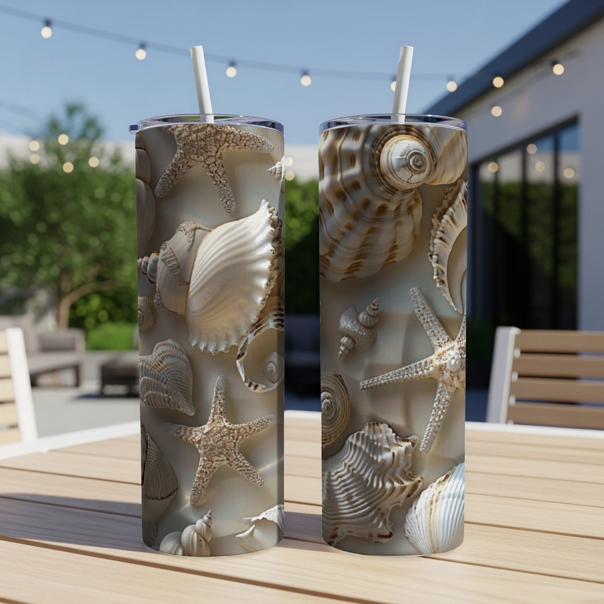 Two tall tumblers featuring a seashell and starfish pattern on a wooden table.