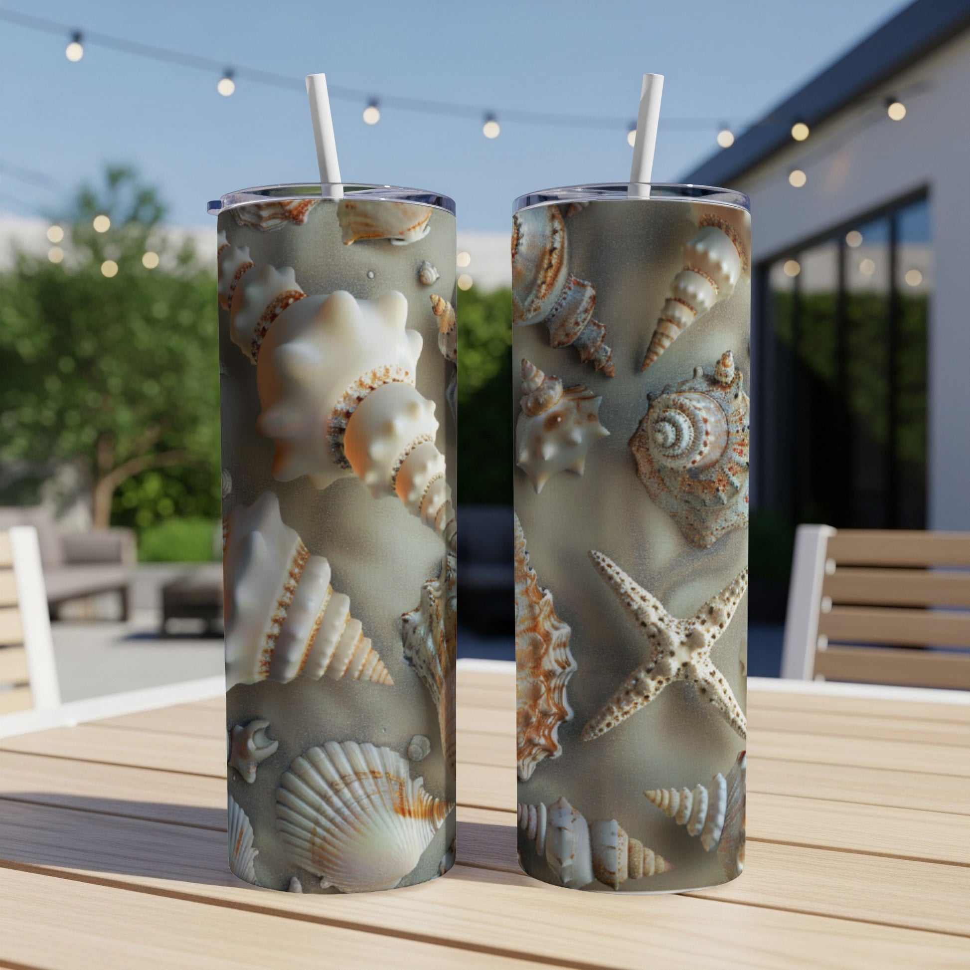Two tumblers with seashell patterns on a wooden table outdoors.