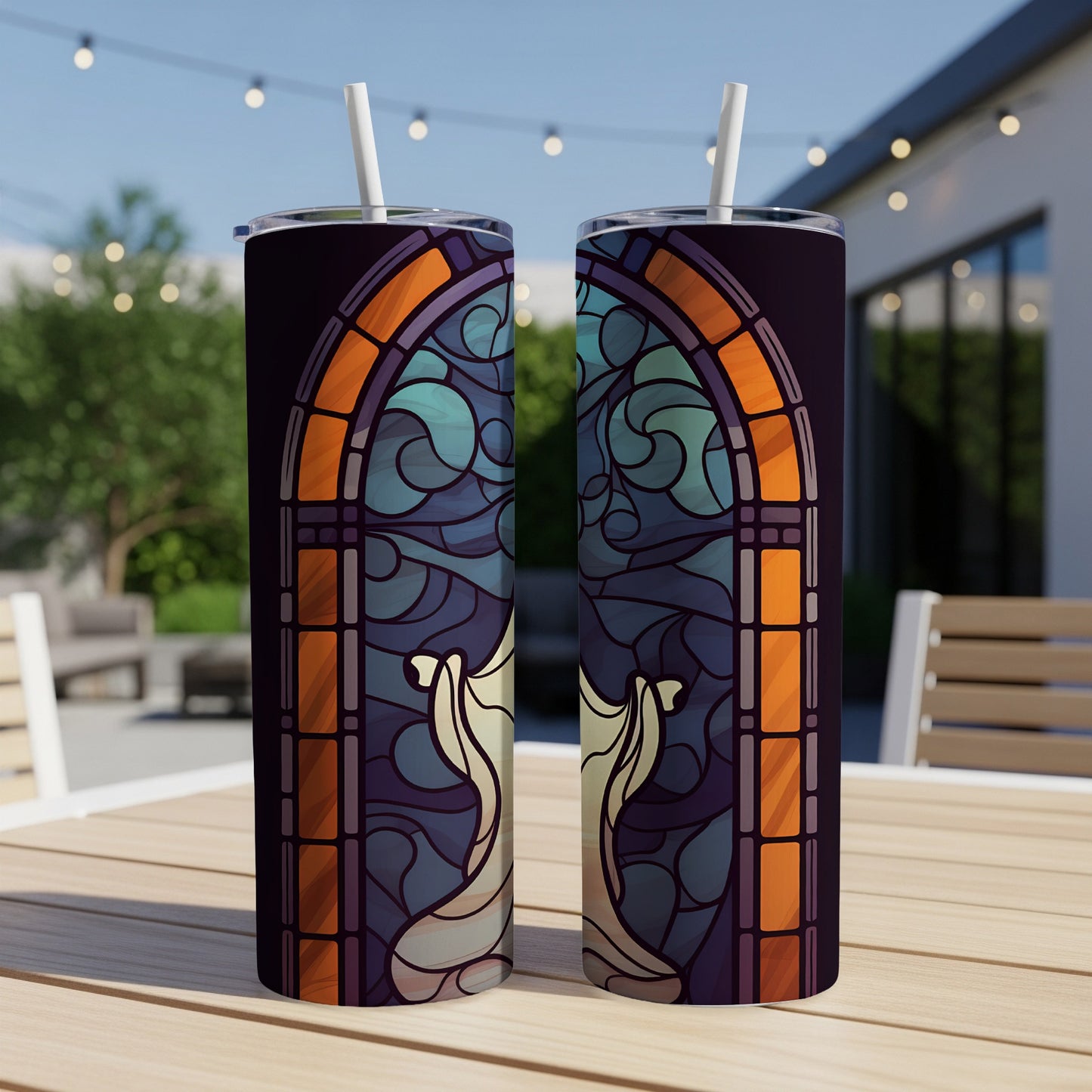 Two tumblers with stained glass angel design displayed on a wooden table.